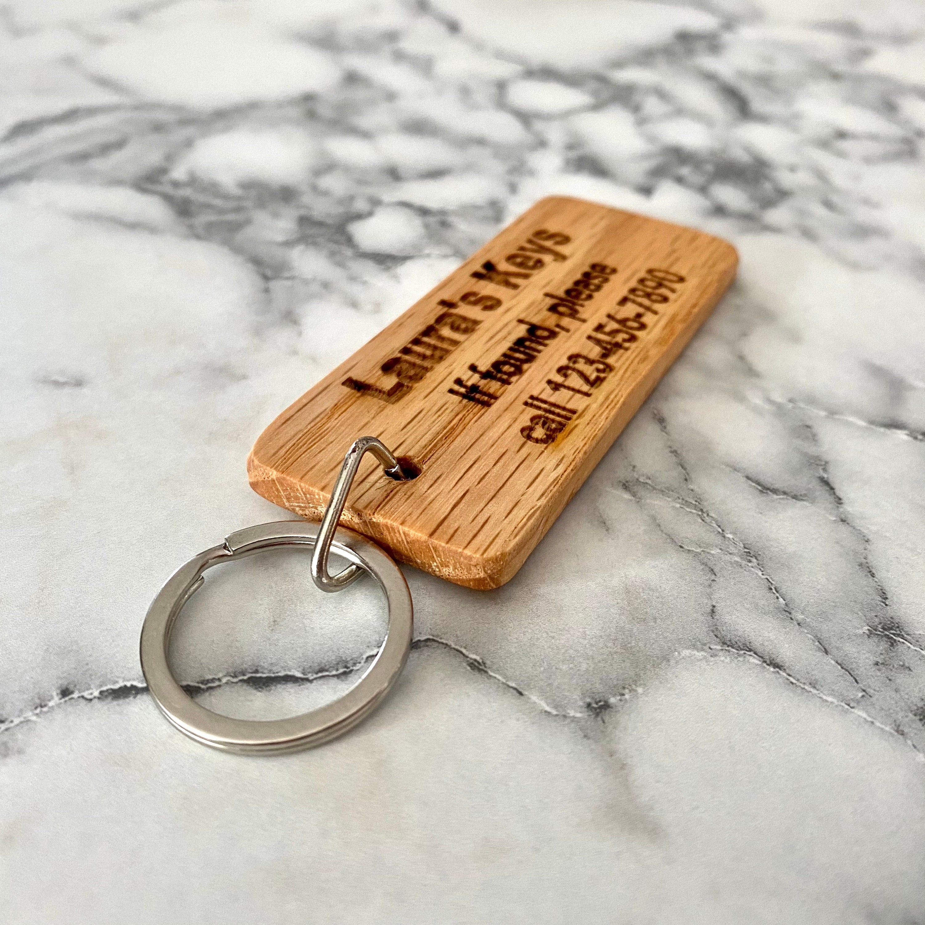 Personalized engraved wood keychain with contact information, crafted from solid oak, showcasing custom engraving and natural finish.