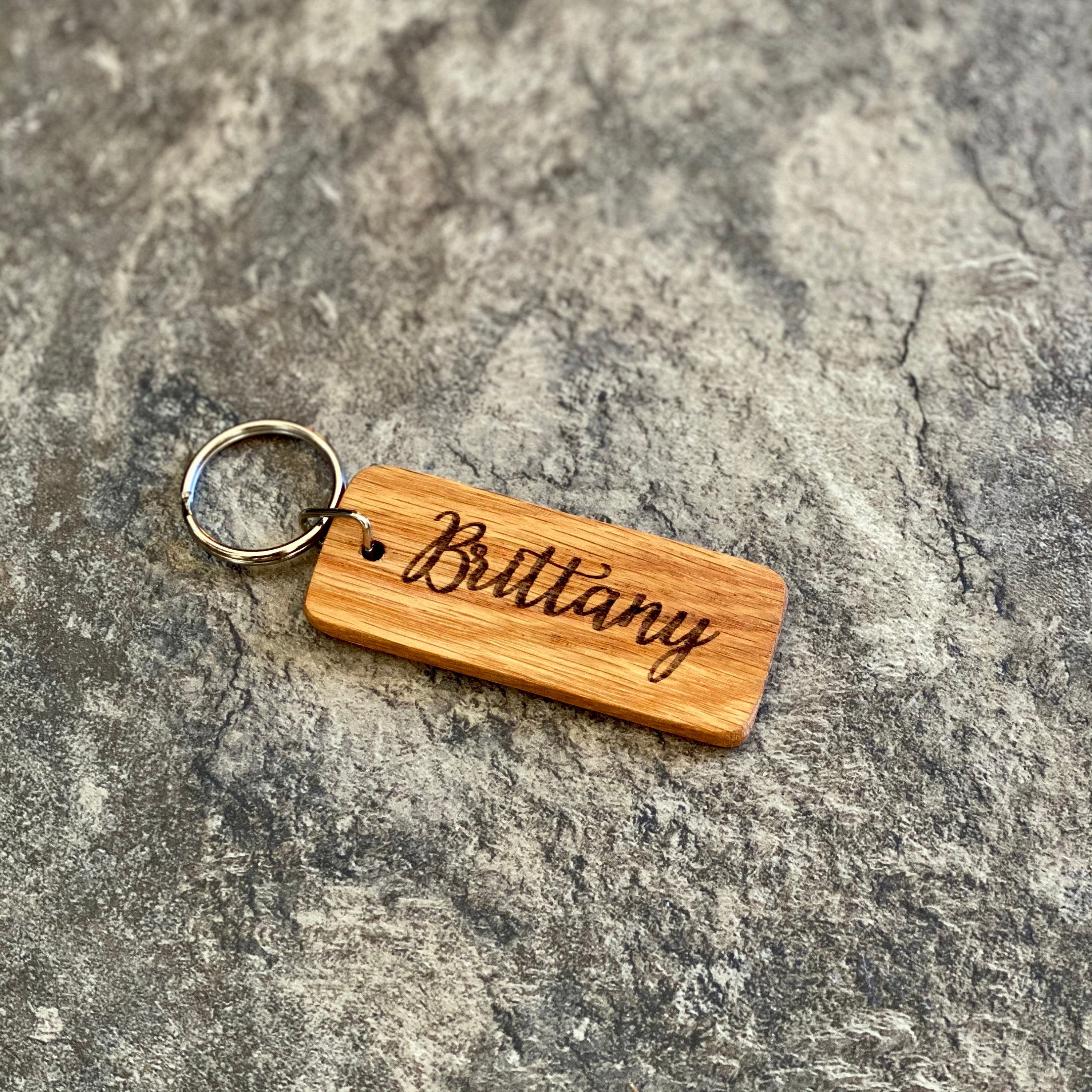 A rustic Pine Tree Engraved Wood Keychain made from solid hardwood oak, featuring a detailed pine tree silhouette and space for personalized text.