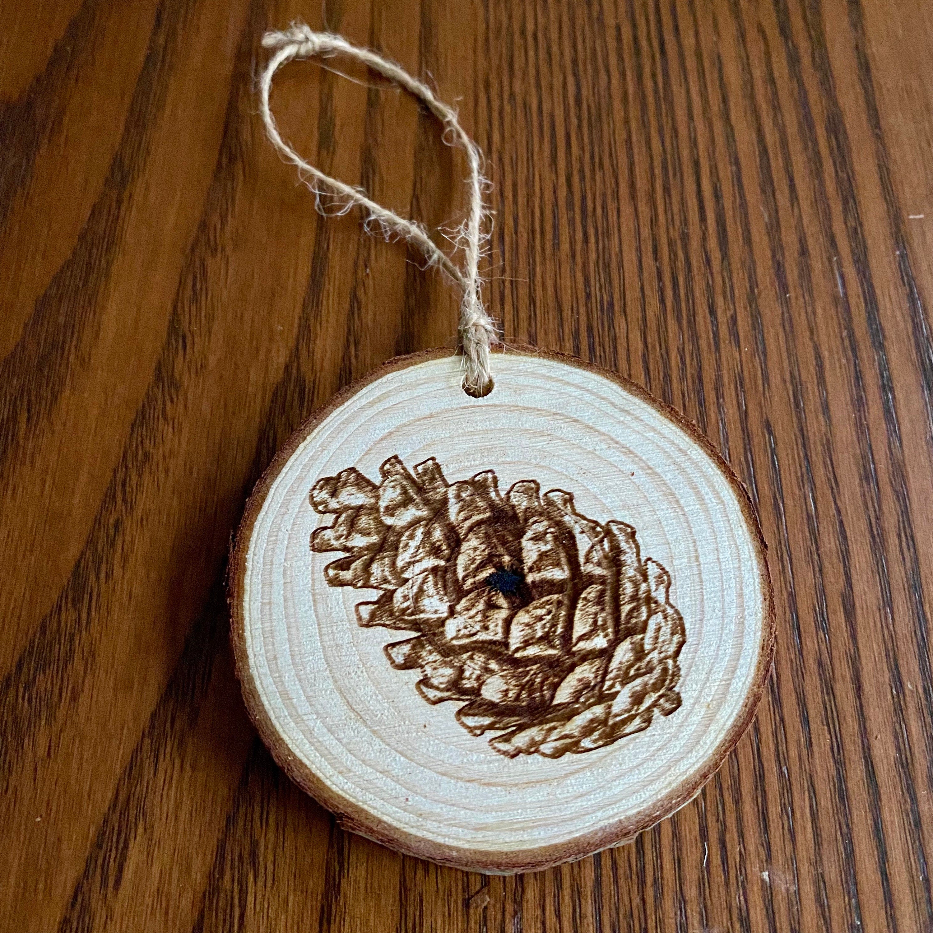 Rustic pinecone engraved wood Christmas ornament with twine, perfect for nature lovers and personalized gifting.