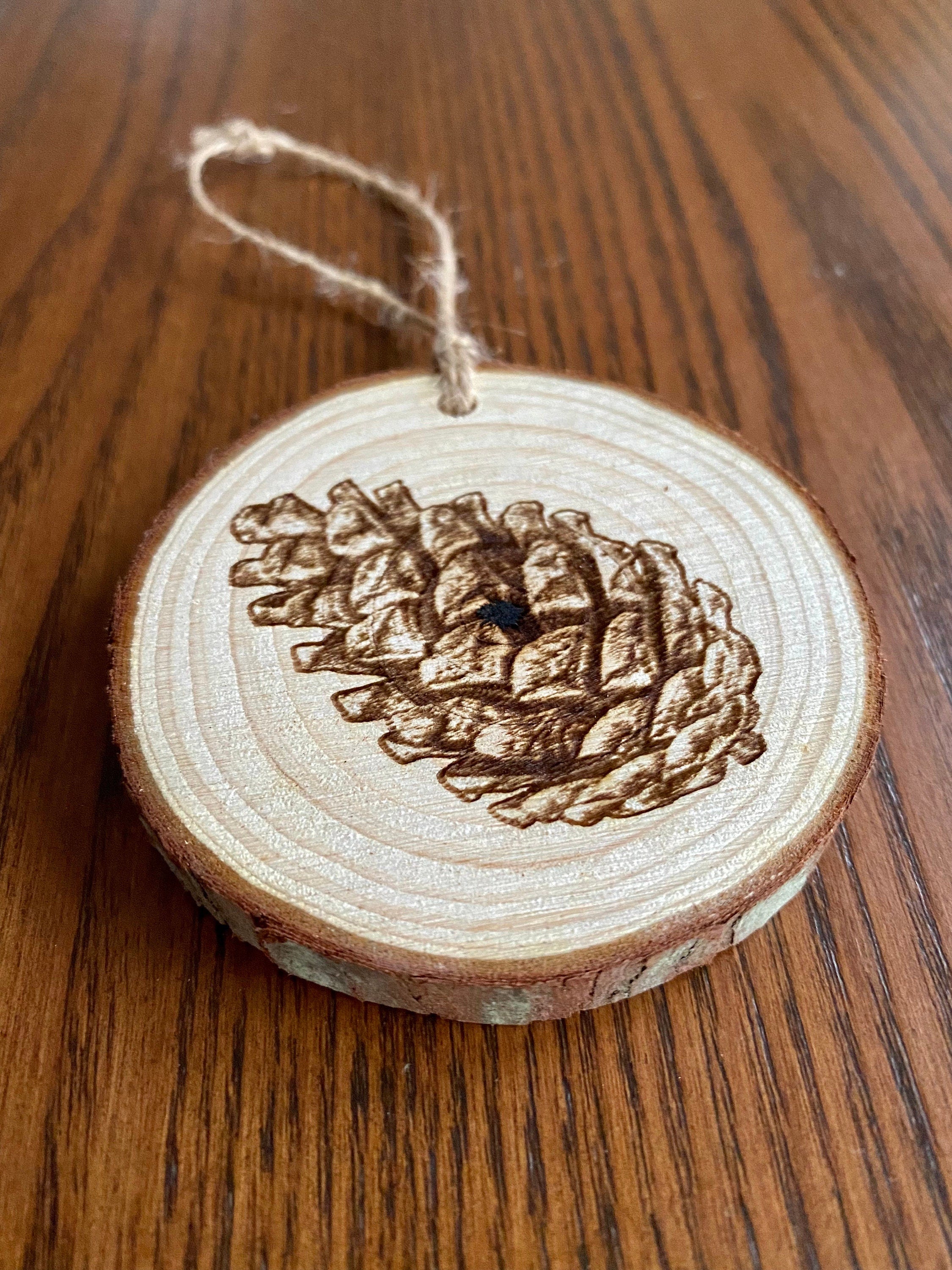 Rustic pinecone engraved wood Christmas ornament with twine, perfect for nature lovers and personalized gifting.