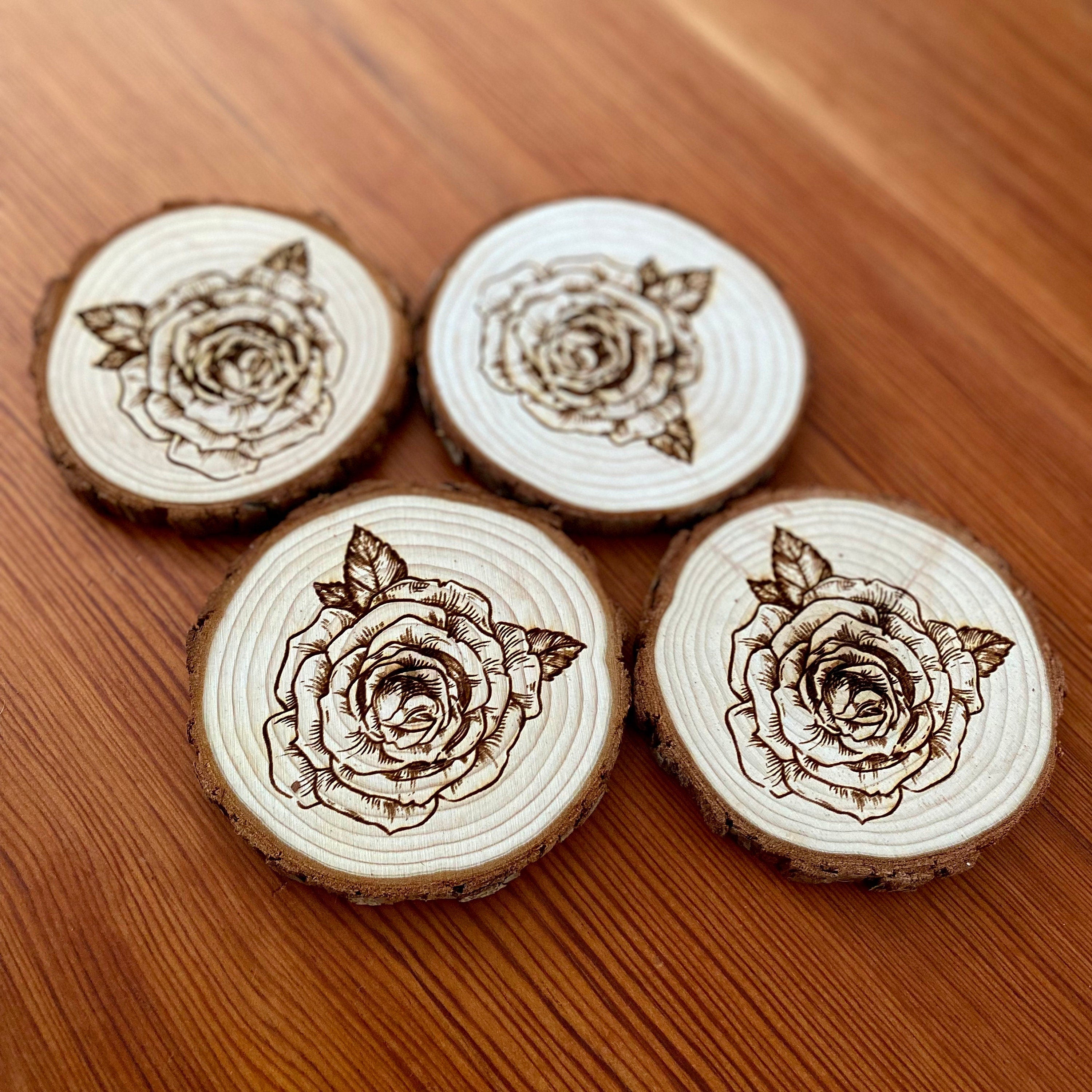 A set of four rose engraved wood coasters, showcasing intricate rose designs on a natural wood surface, ideal for home decor.