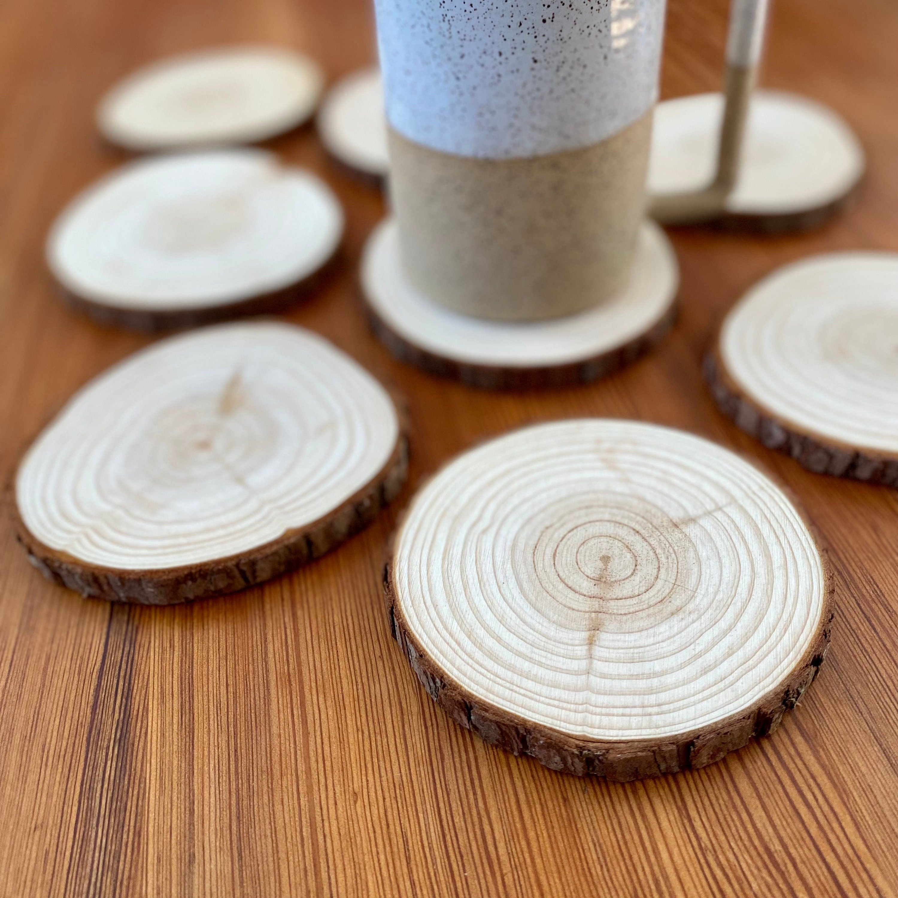 A set of rustic wood slice coasters made from Californian Pine, showcasing their natural grain and smooth finish.