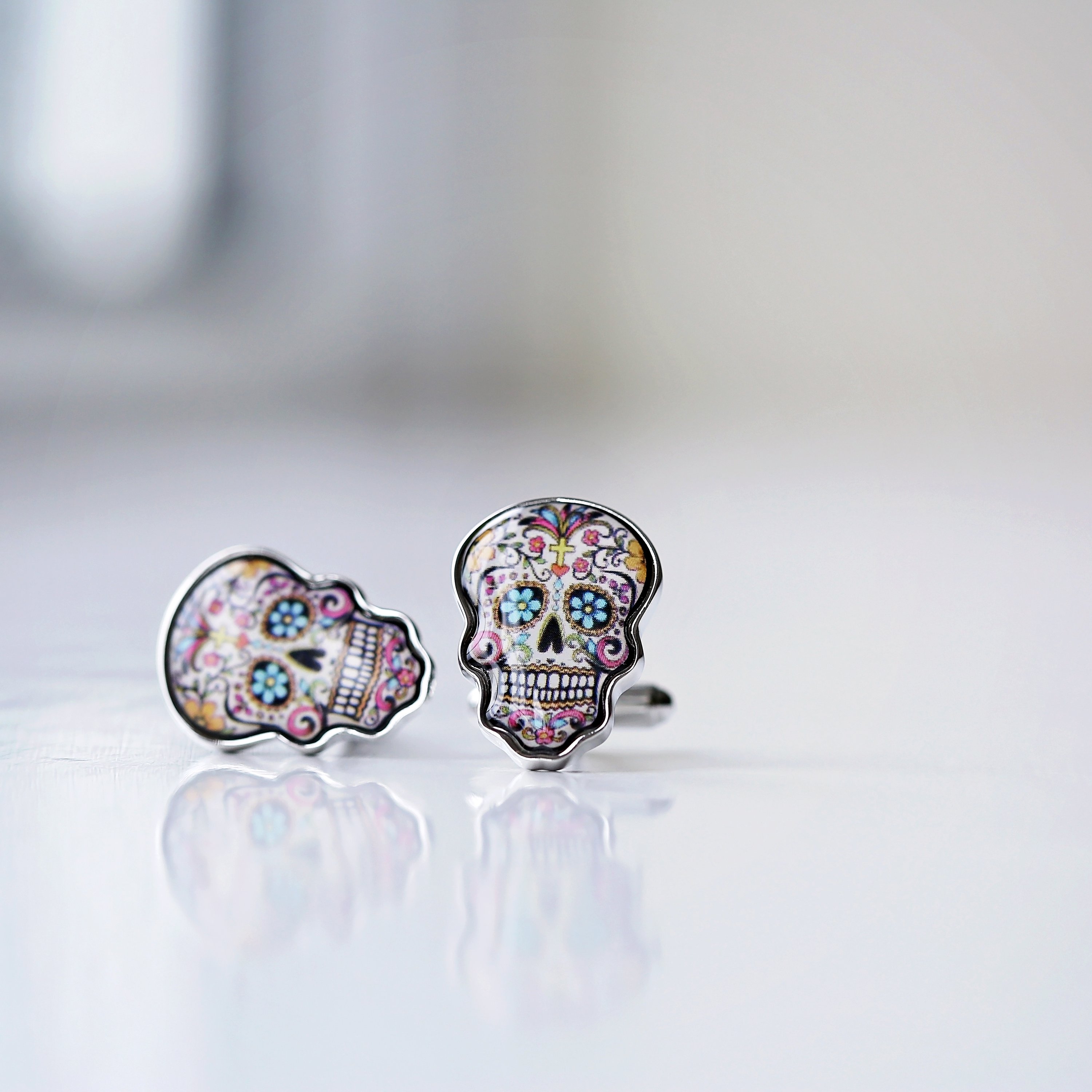 A pair of stylish skull cufflinks displayed in a luxury engraved box, showcasing intricate details and personalization options.