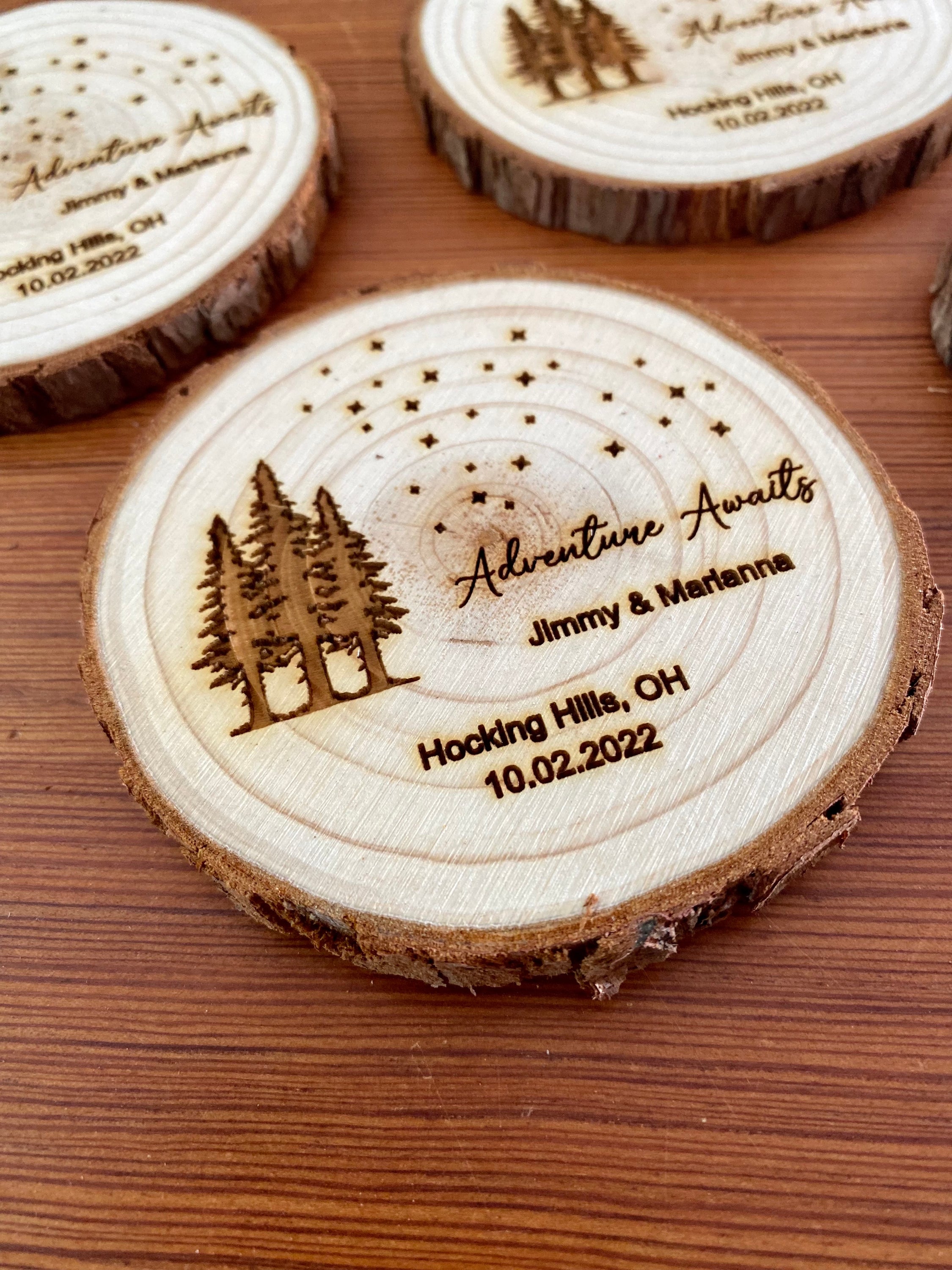 Personalized wood slice coasters with star and tree design, perfect for rustic wedding favors.