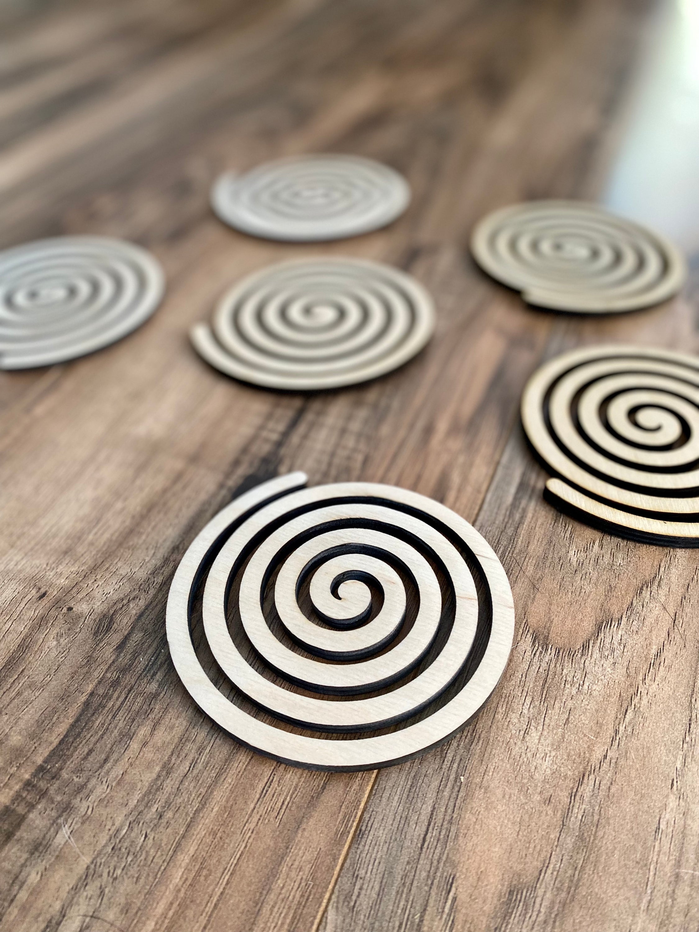 Set of unique wood spiral coasters made from high-quality birch plywood, showcasing a beautiful spiral design.