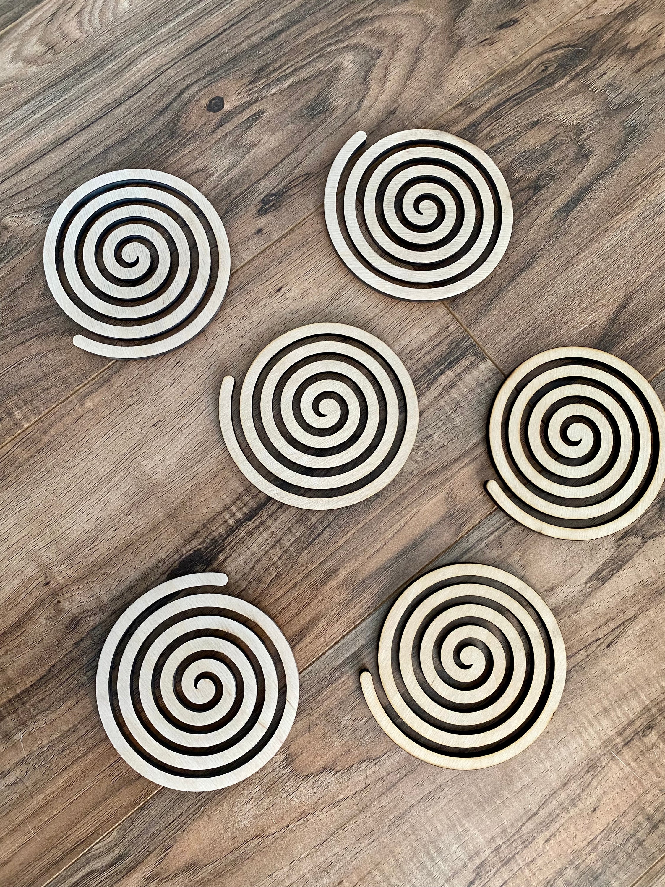 Set of unique wood spiral coasters made from high-quality birch plywood, showcasing a beautiful spiral design.