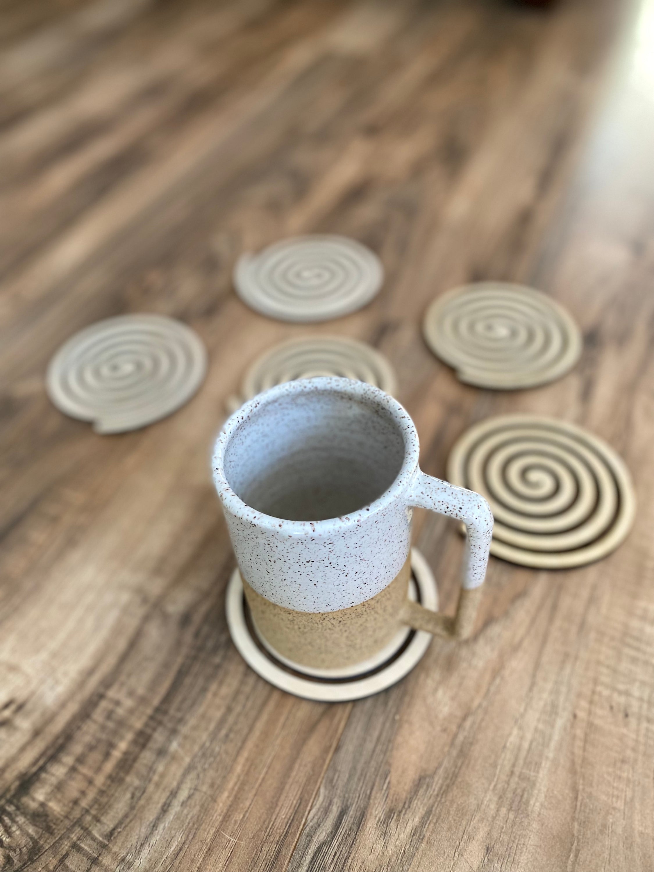 Set of unique wood spiral coasters made from high-quality birch plywood, showcasing a beautiful spiral design.