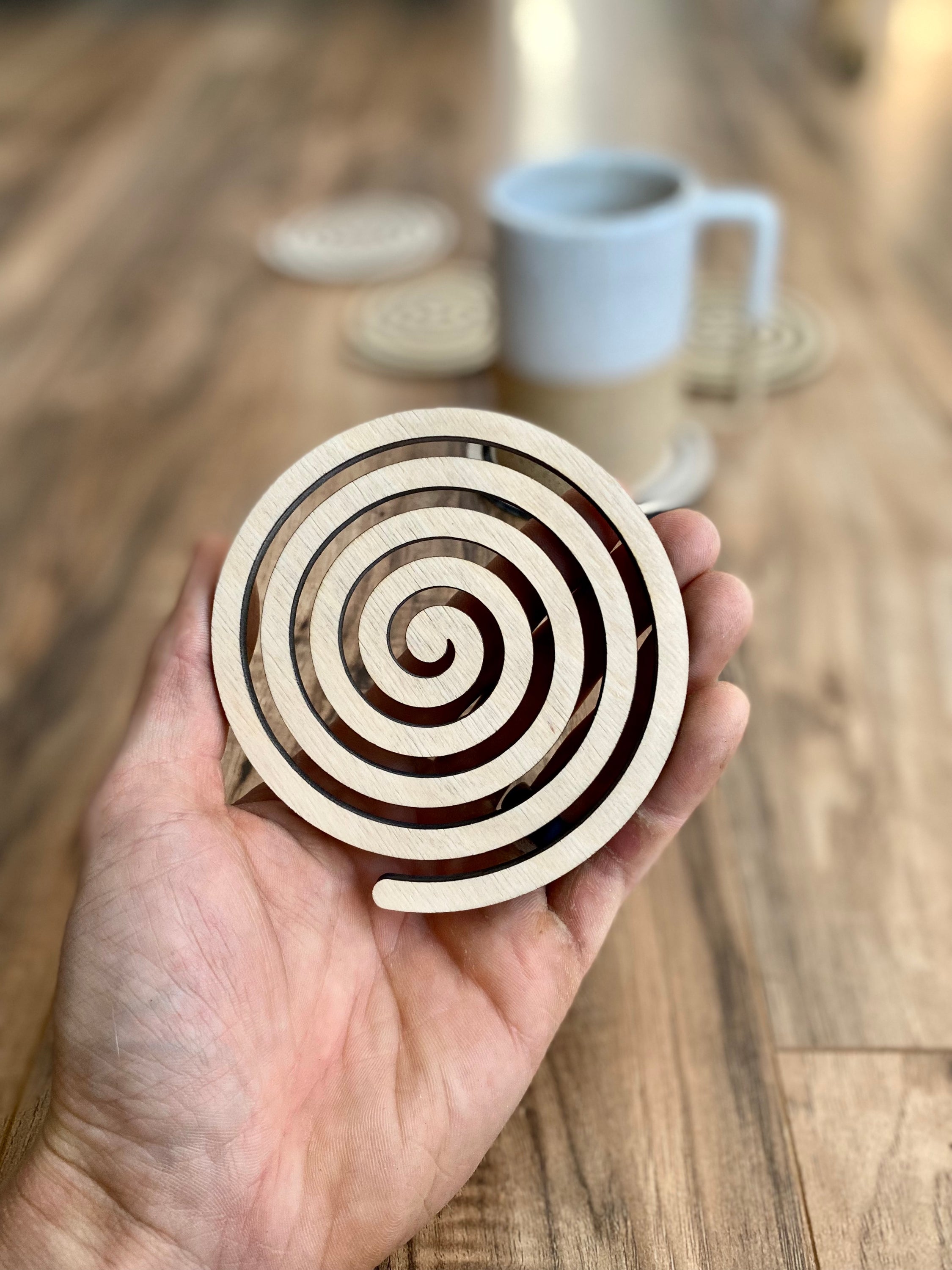 Set of unique wood spiral coasters made from high-quality birch plywood, showcasing a beautiful spiral design.