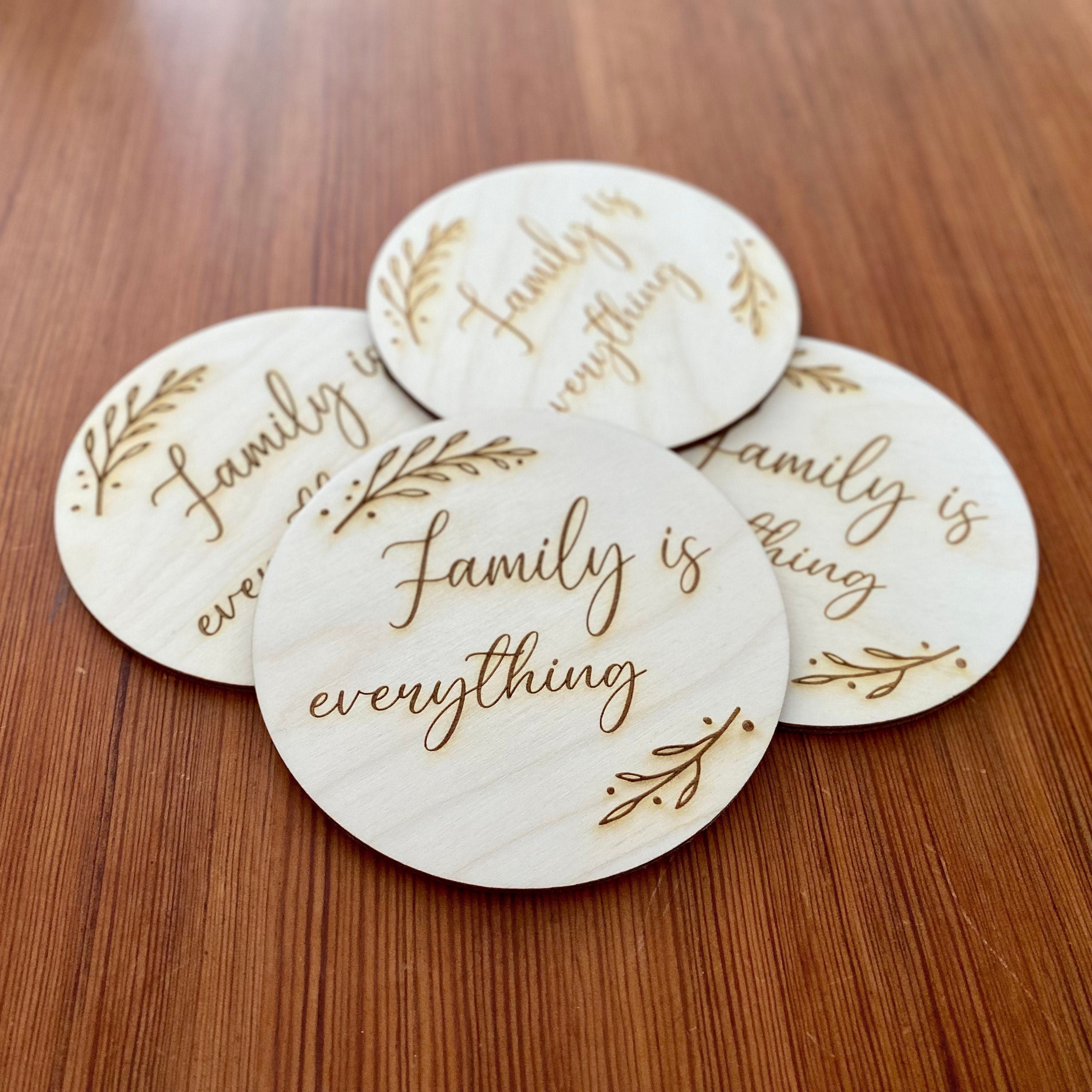 A set of wooden coasters engraved with 'Family is everything' and a leaf border, showcasing their rustic charm and high-quality finish.