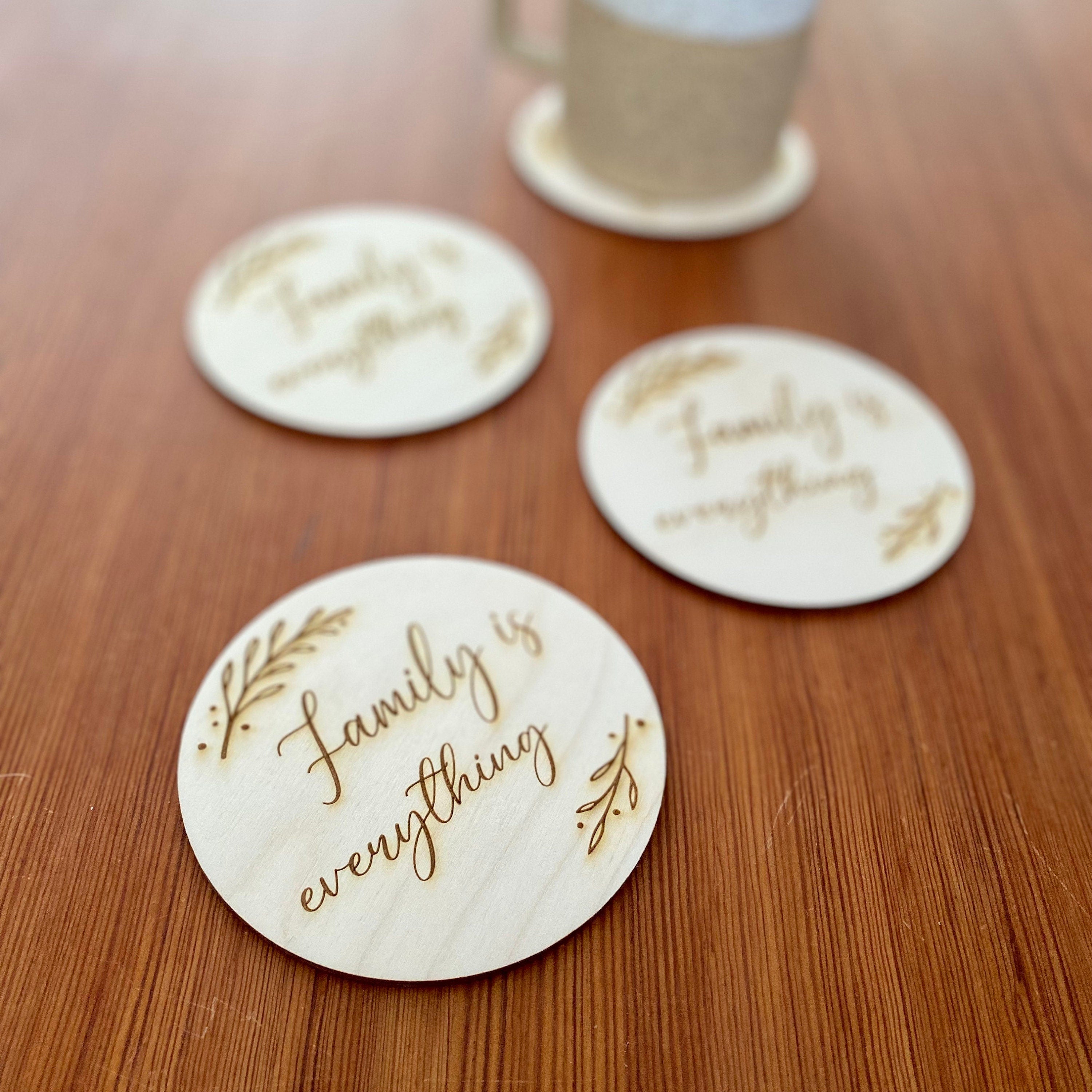 A set of wooden coasters engraved with 'Family is everything' and a leaf border, showcasing their rustic charm and high-quality finish.