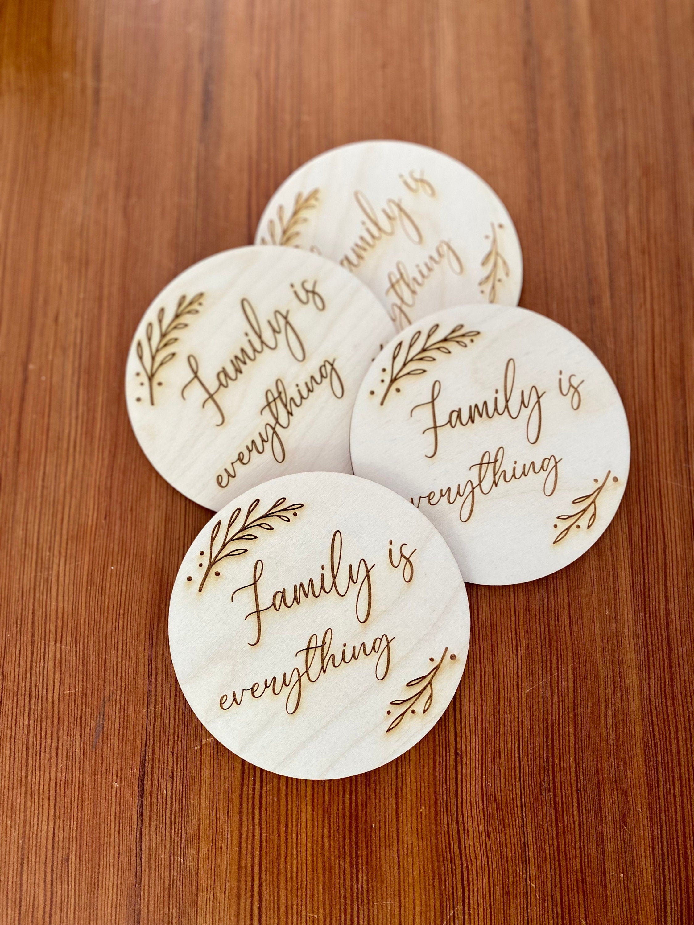 A set of wooden coasters engraved with 'Family is everything' and a leaf border, showcasing their rustic charm and high-quality finish.