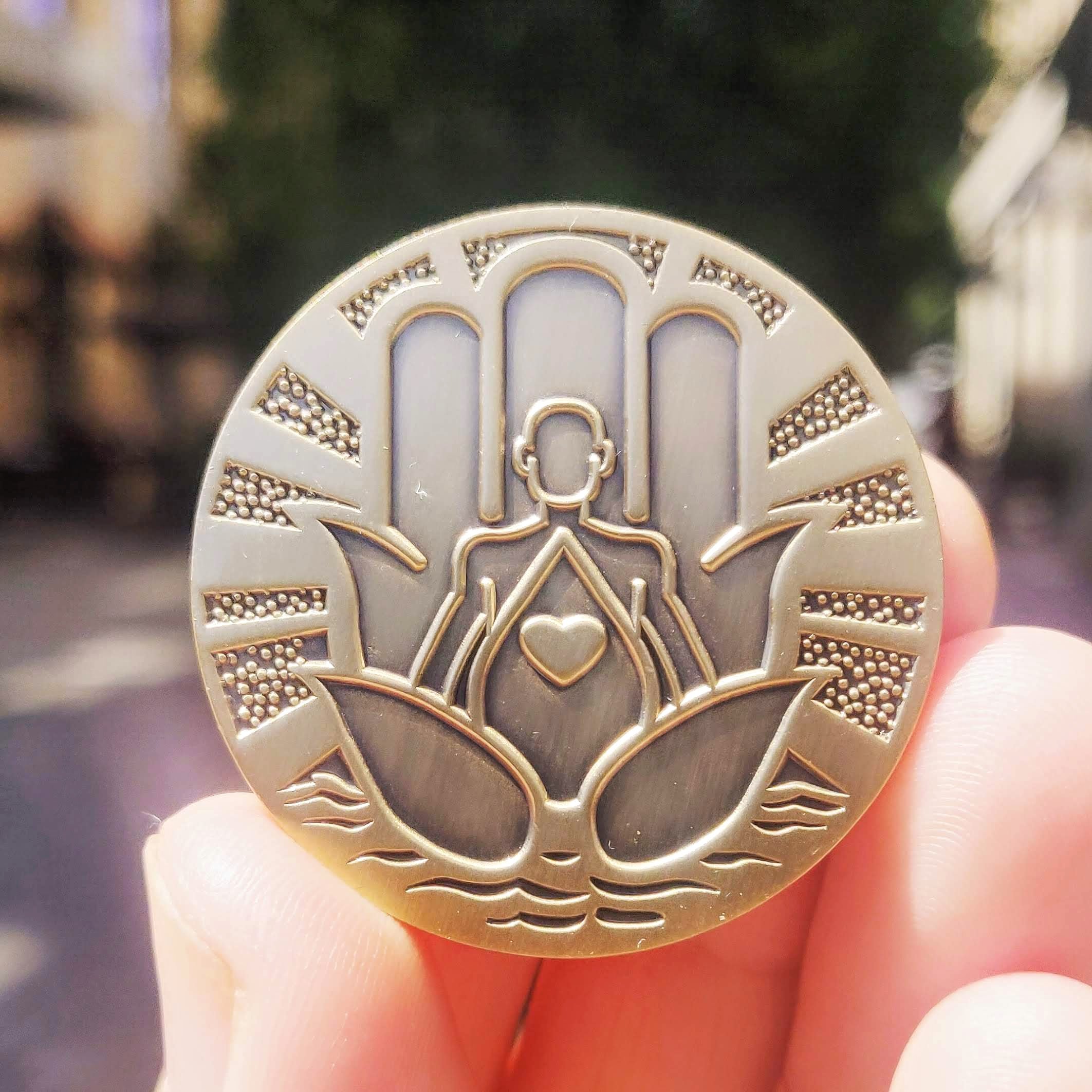 Be Here Now Mantra Medallion featuring a calming design, perfect for mindfulness and yoga practices, held in a hand against a serene background.