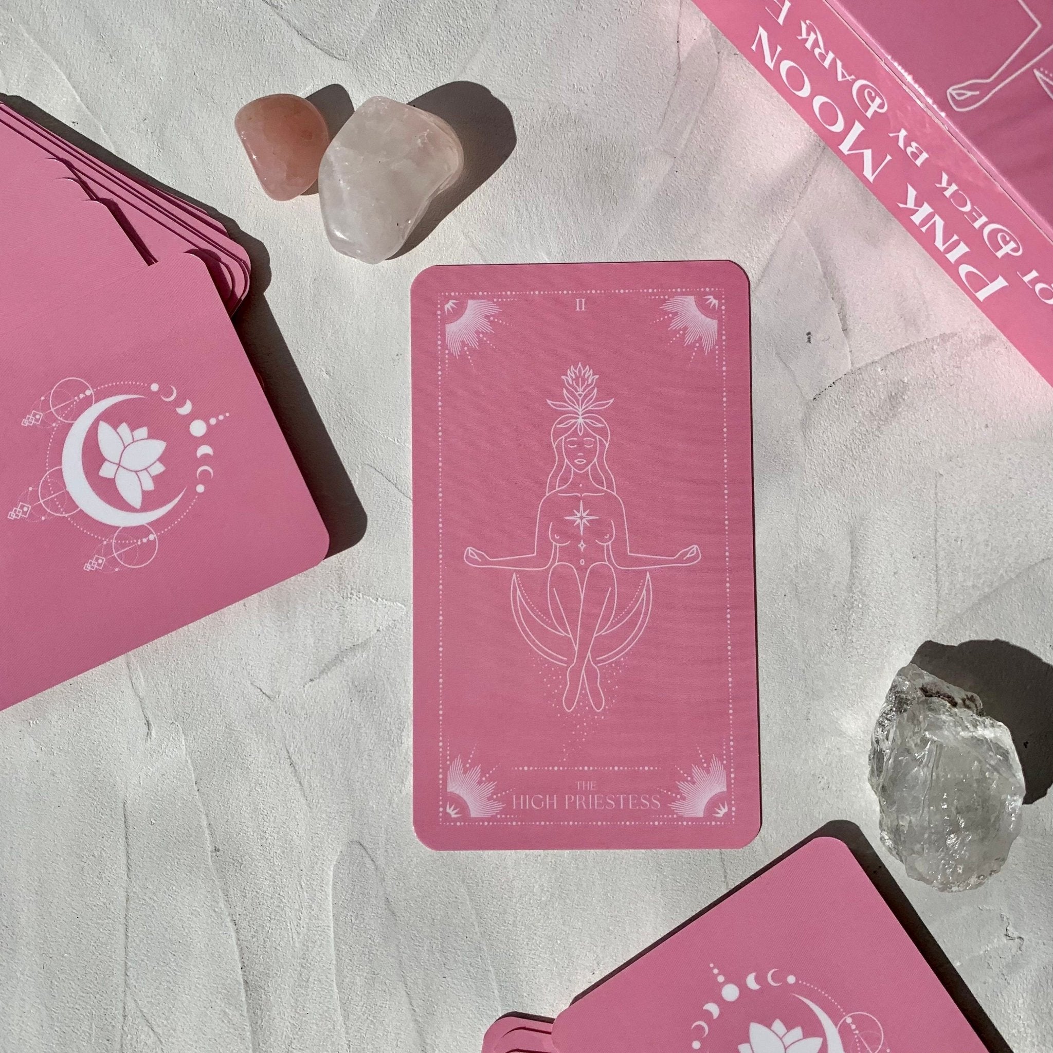 Pink Moon Tarot Deck featuring 78 beautifully designed cards, a guidebook, and accessories including a velvet bag and tarot cloth.