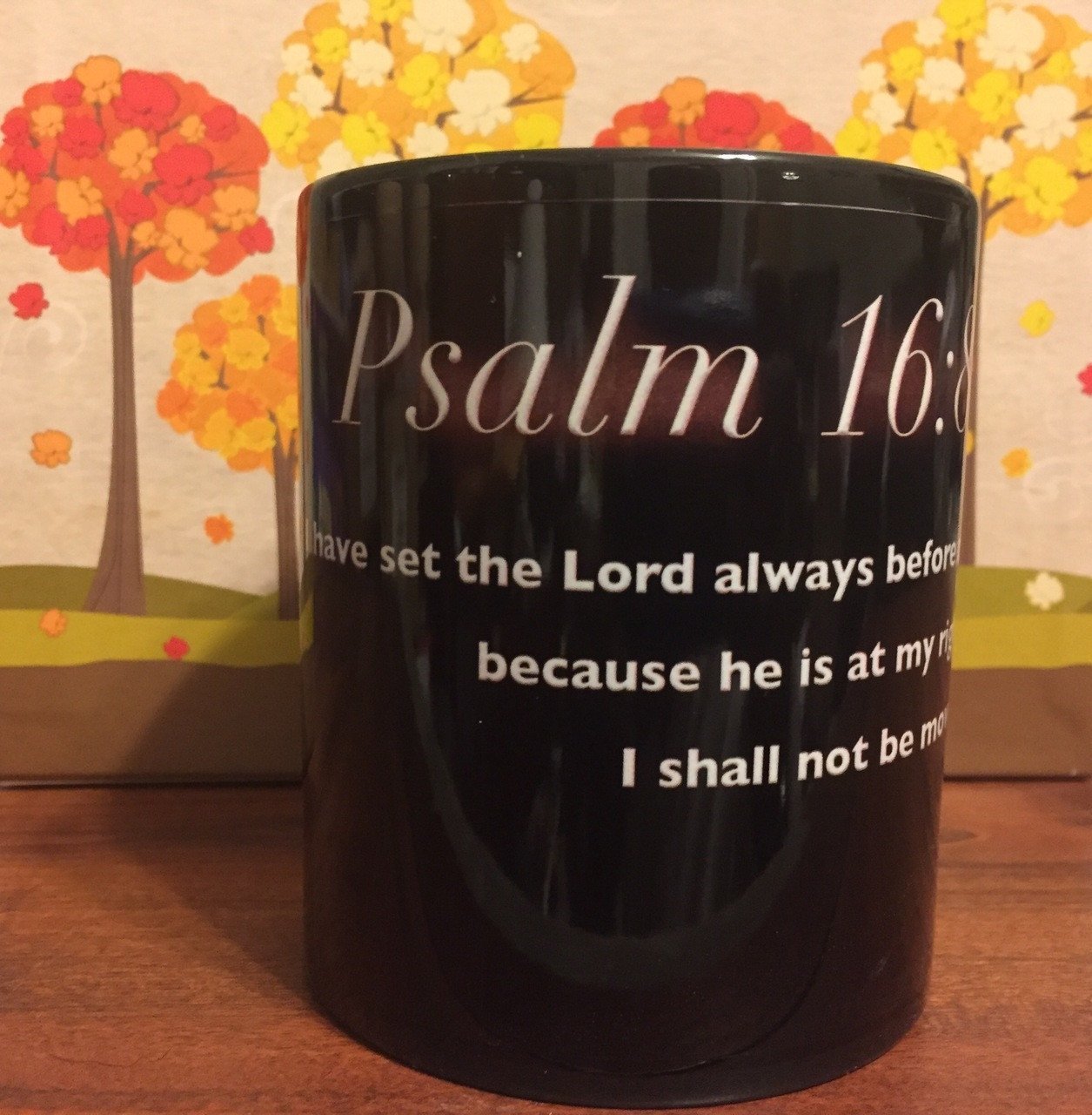 Black glossy ceramic mug featuring the biblical verse Psalms 16:8, perfect for daily use.