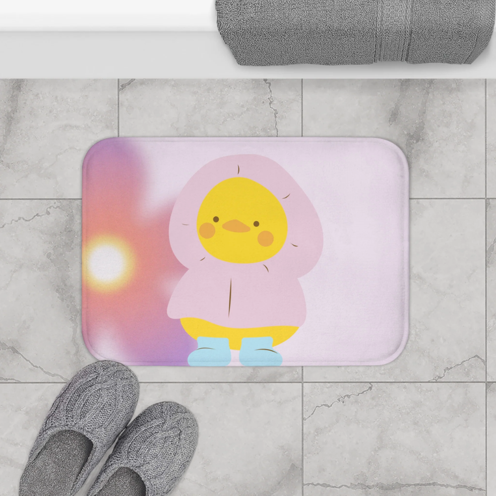 A cute bath mat featuring an adorable baby duck wearing a raincoat, designed for safety with anti-slip backing.