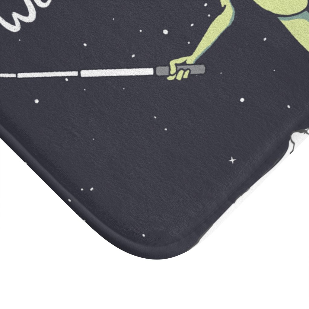 A colorful bath mat featuring a playful alien taking a selfie, designed with anti-slip backing and durable edges.