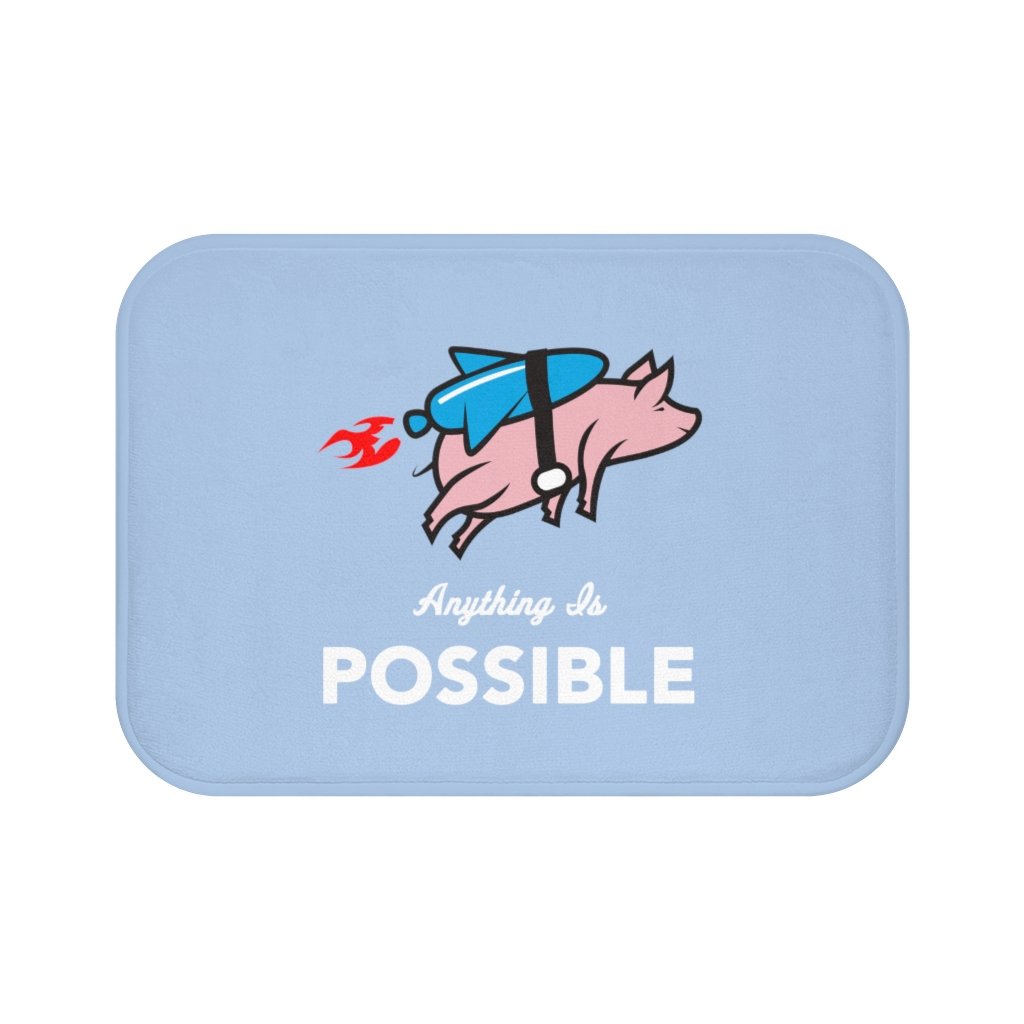 A colorful bath mat featuring a whimsical flying pig with a rocket, designed for safety with anti-slip backing and soft microfiber material.