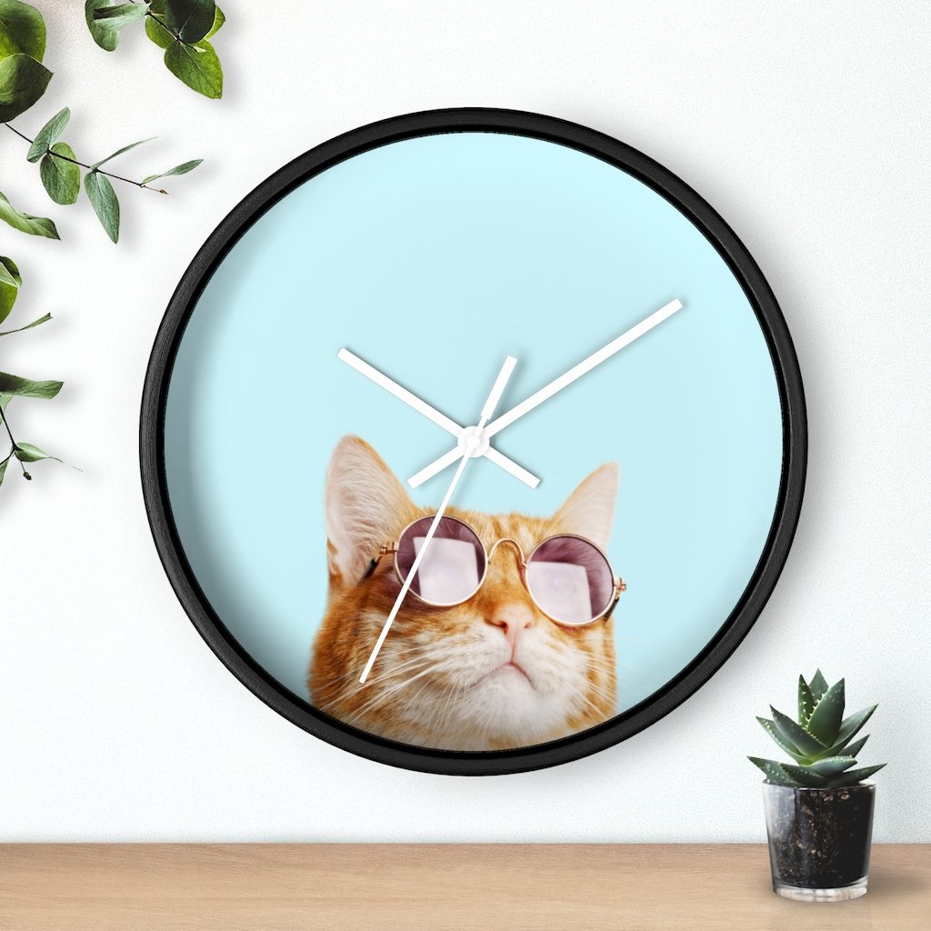 A whimsical wall clock featuring a cat design with a wooden frame and plexiglass face, ideal for indoor use.