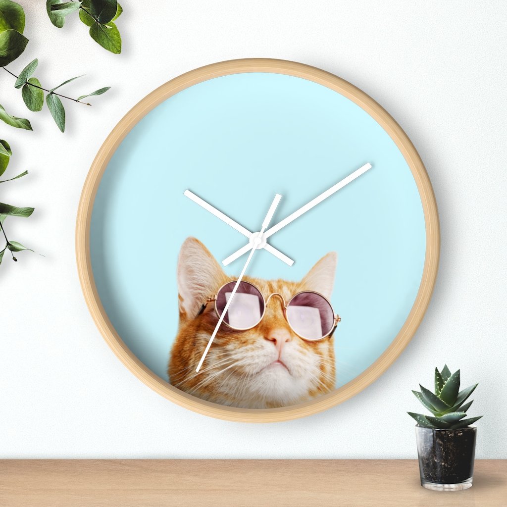 A whimsical wall clock featuring a cat design with a wooden frame and plexiglass face, ideal for indoor use.