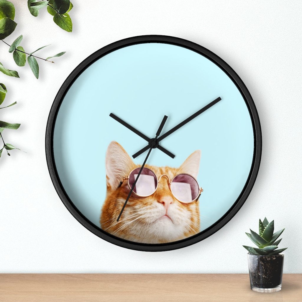 A whimsical wall clock featuring a cat design with a wooden frame and plexiglass face, ideal for indoor use.