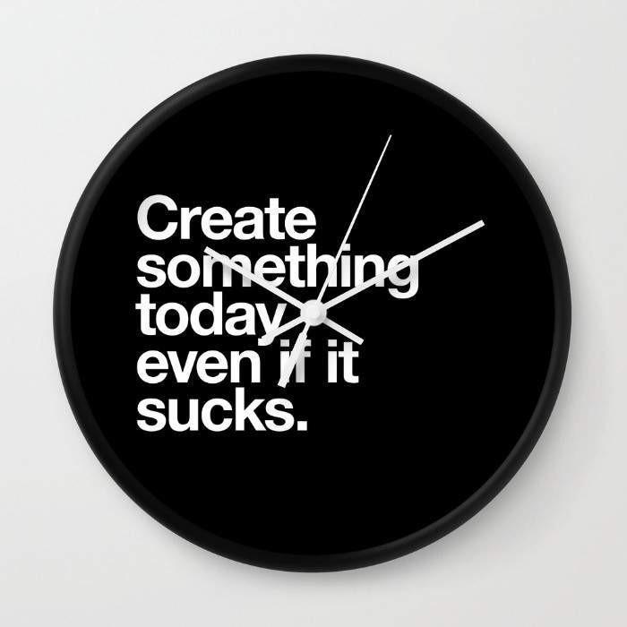 A stylish wall clock with a motivational quote, available in black or white frames, featuring a clear plexiglass face and contrasting hands.