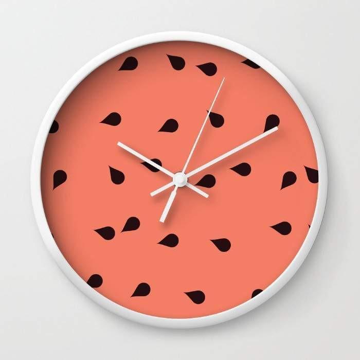 A stylish SCATTERED WATERMELON Wall Clock with a unique design, available in black or white frames, featuring a clear plexiglass face and black or white hands.