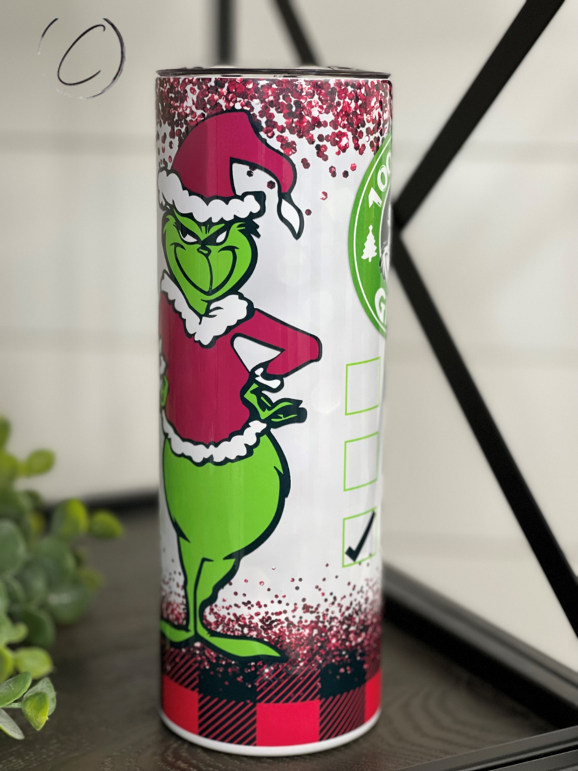 A 20oz skinny tumbler featuring a vibrant Grinch design, perfect for holiday drinks, with a reusable straw included.