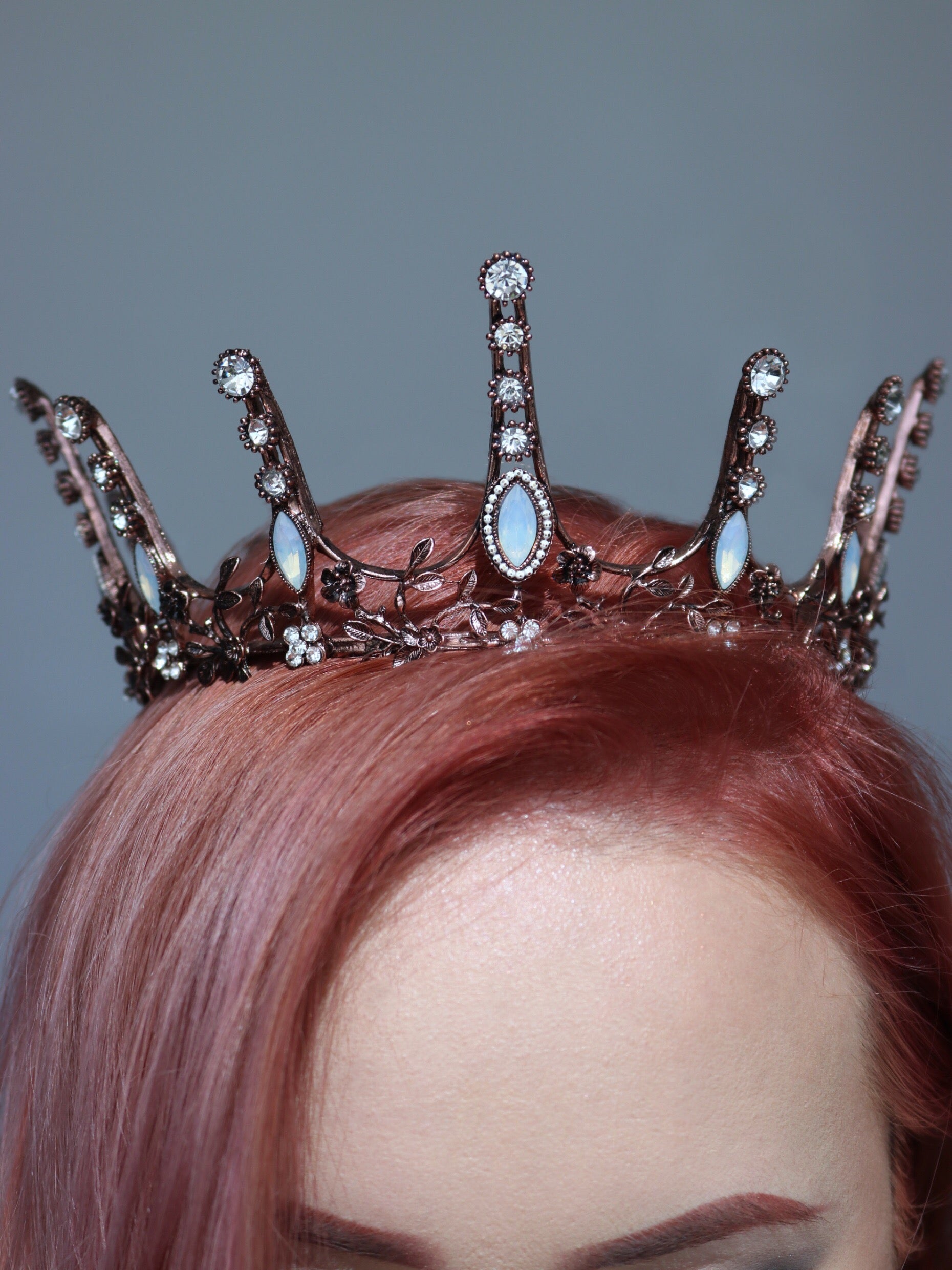 Aggressively Rosy Crown Tiara in rose gold with faux opal accents, designed to resemble skyscrapers, perfect for royal occasions.