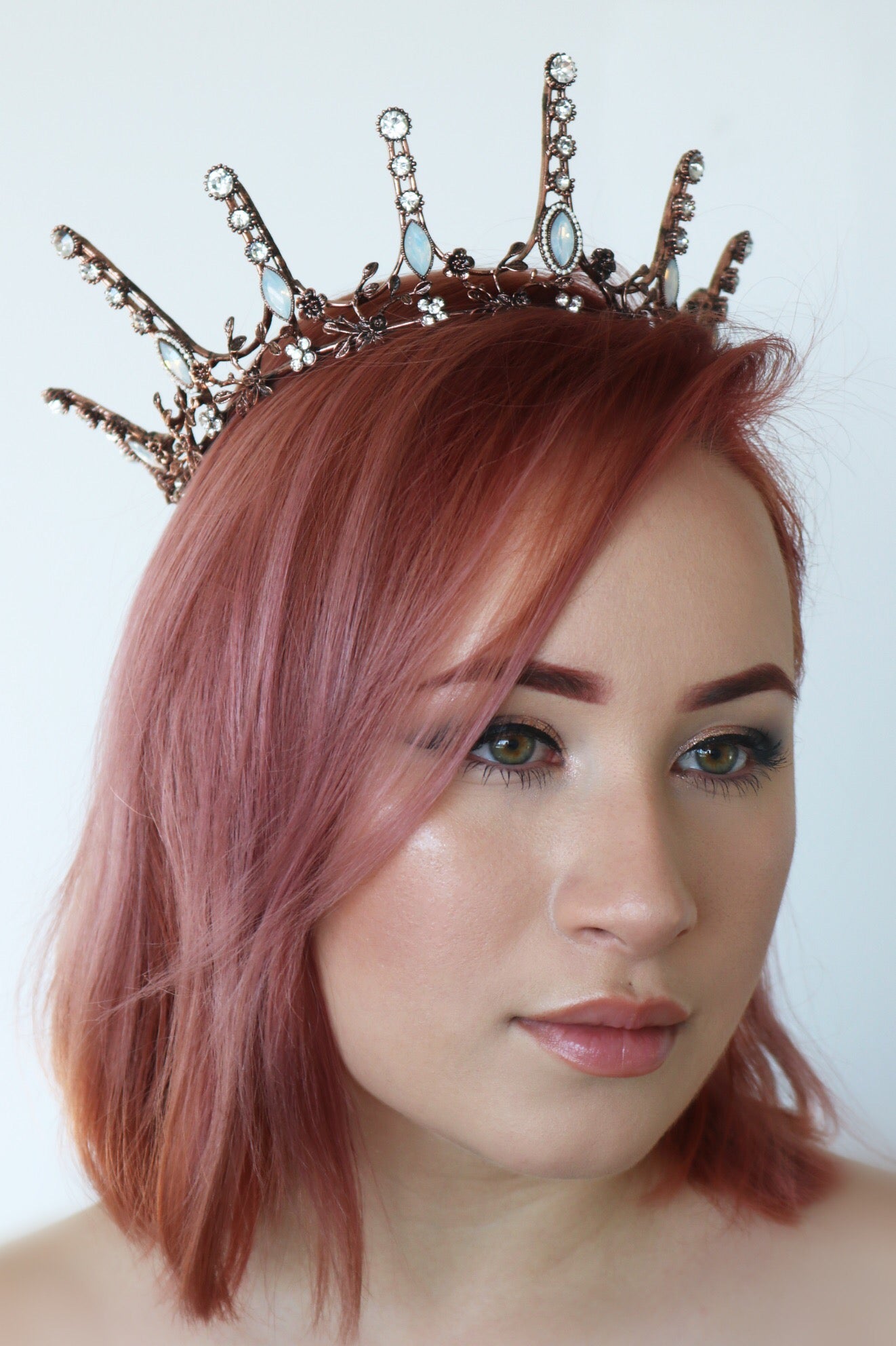 Aggressively Rosy Crown Tiara in rose gold with faux opal accents, designed to resemble skyscrapers, perfect for royal occasions.