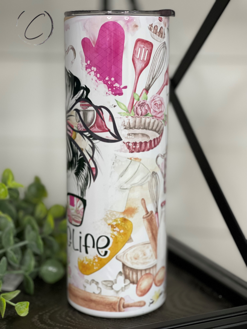 A stylish 20oz skinny tumbler with a full wrap design featuring vibrant graphics, accompanied by a reusable straw.