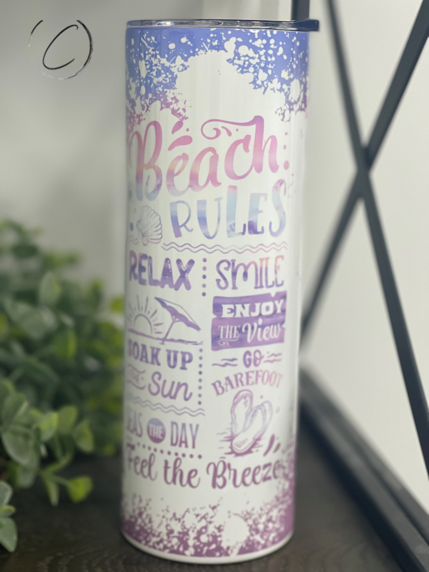 A stylish Beach Rules 20oz Skinny Tumbler featuring a vibrant beach-themed design, complete with a reusable straw.