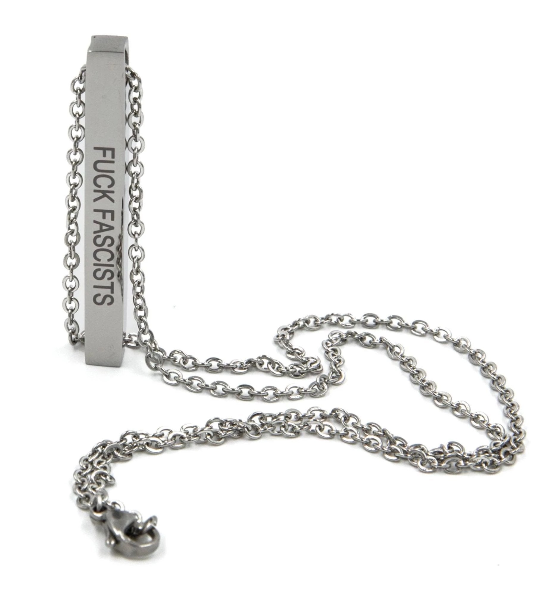 A stainless steel bar necklace engraved with 'Fuck Fascists' and 'Burn the Patriarchy', featuring a sleek design and an 18.5-inch chain.