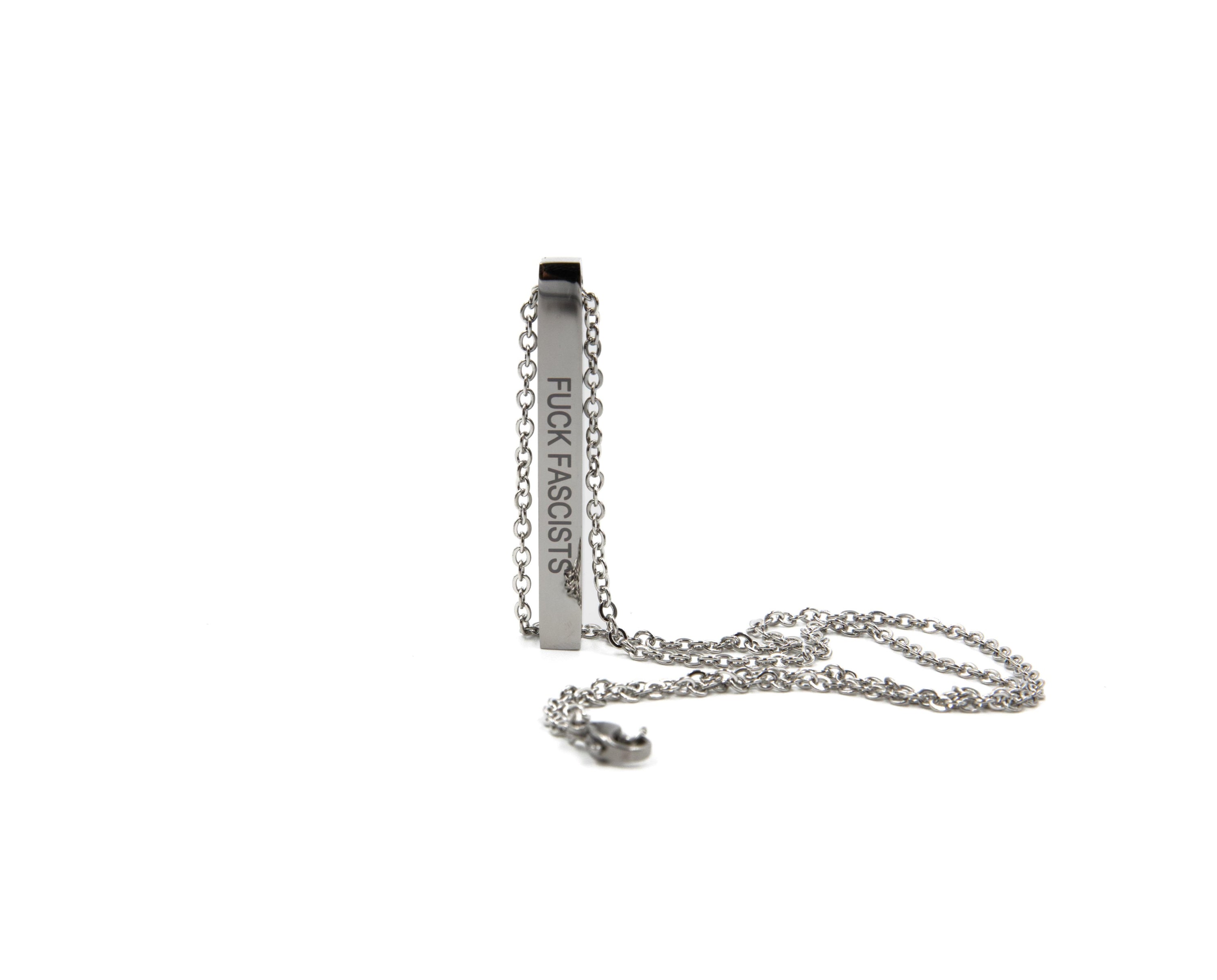 A stainless steel bar necklace engraved with 'Fuck Fascists' and 'Burn the Patriarchy', featuring a sleek design and an 18.5-inch chain.