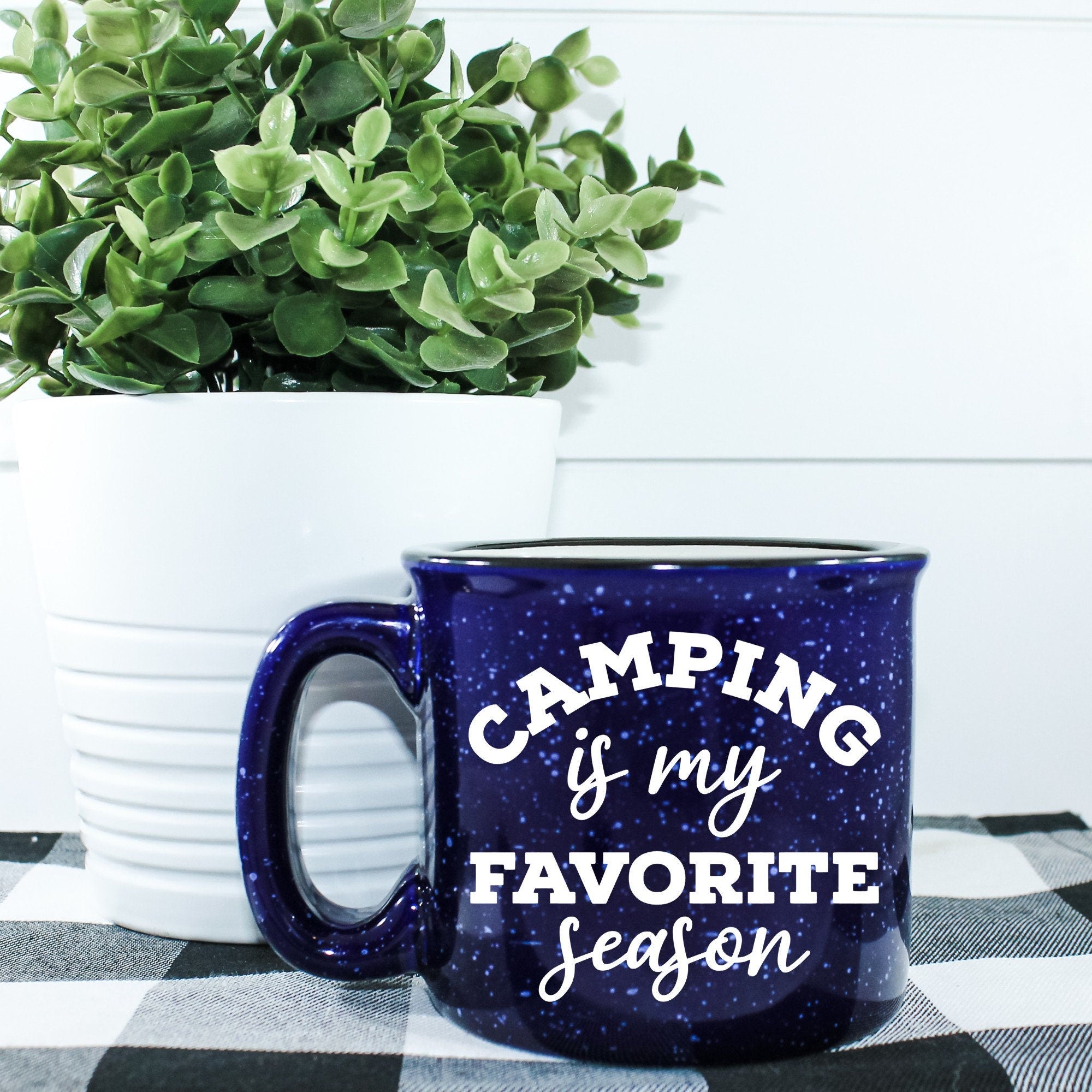 Ceramic campfire mug with 'Camping Is My Favorite Season' design, perfect for outdoor enthusiasts.