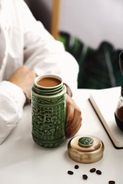 The Determination Tumbler featuring Persimmon Calyx and Jade Dragon patterns, made of tourmaline ceramic with an acrylic resin lid.