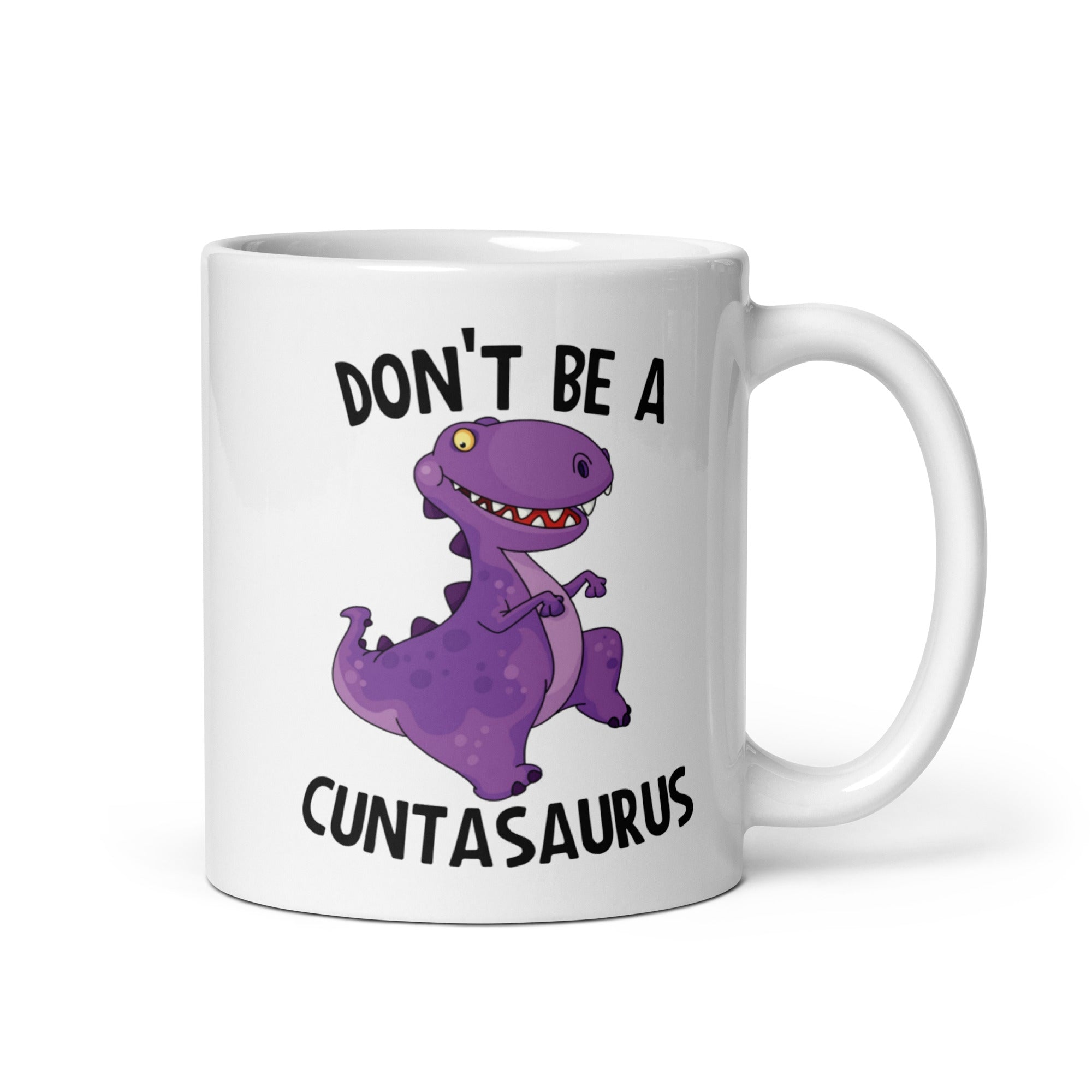 A glossy ceramic mug featuring the humorous phrase 'Don't Be A Cuntasaurus' printed on both sides, available in two sizes.