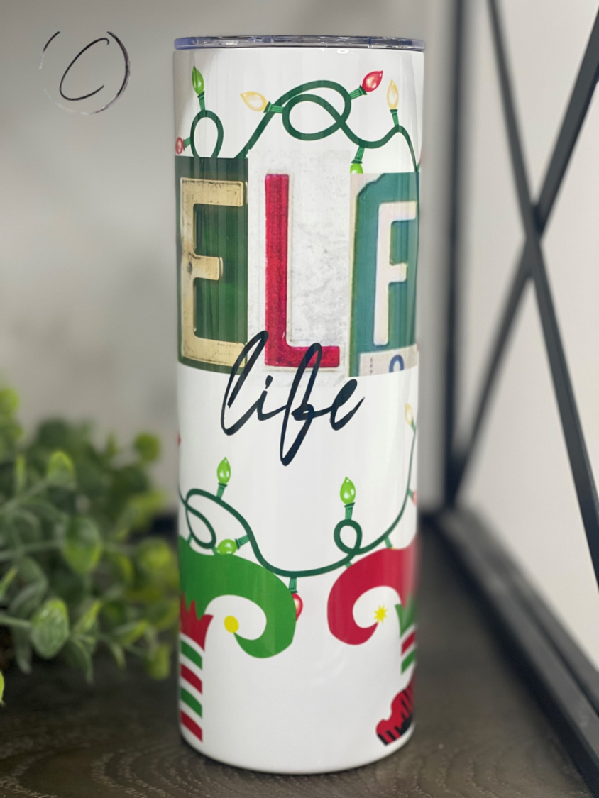 Elf Life 20oz Skinny Tumbler featuring a vibrant design, reusable straw, and durable construction for hot and cold beverages.