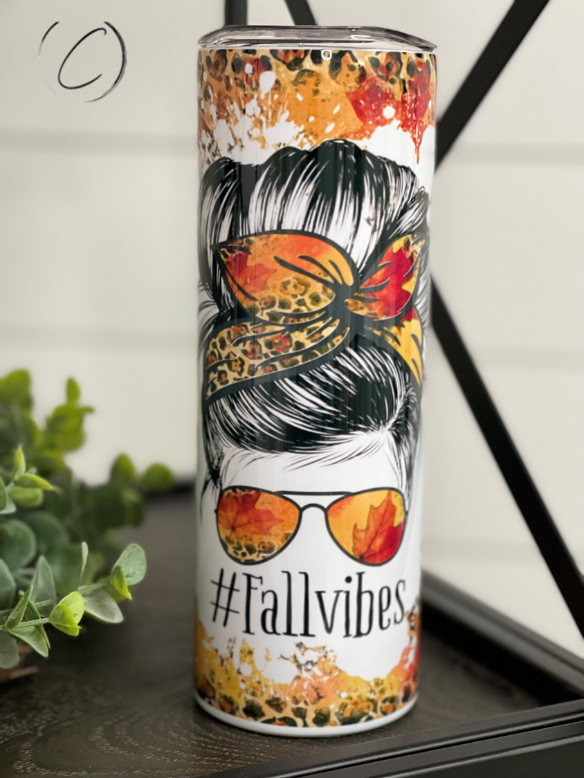 A stylish 20oz skinny tumbler featuring a vibrant fall-themed design, complete with a reusable straw.