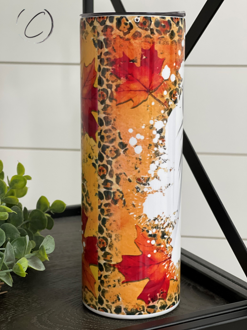 A stylish 20oz skinny tumbler featuring a vibrant fall-themed design, complete with a reusable straw.