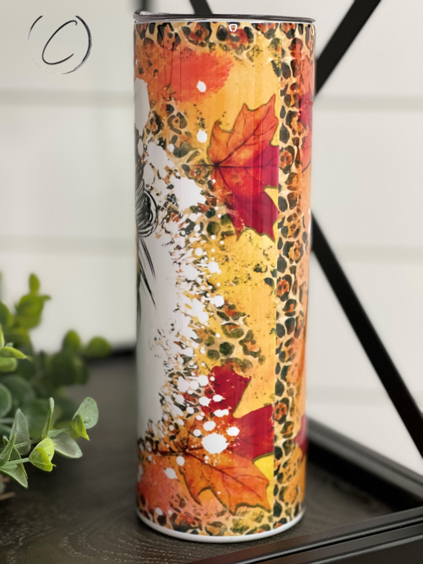 A stylish 20oz skinny tumbler featuring a vibrant fall-themed design, complete with a reusable straw.