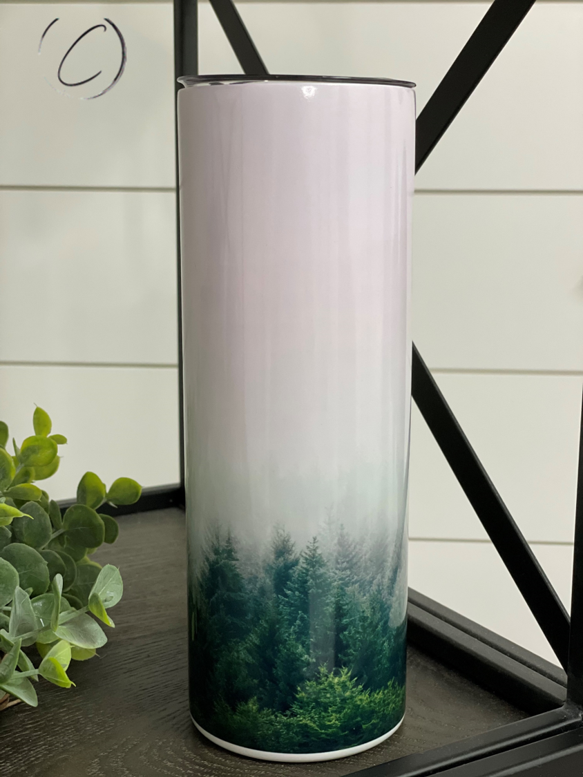 Forest Fog 20oz UV Orange Skinny Tumbler showcasing its vibrant color-changing design in sunlight, complete with a reusable straw.