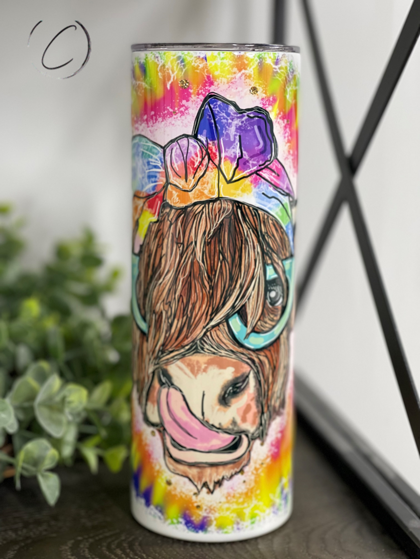 A colorful Groovy Highland Cow 20oz skinny tumbler featuring a vibrant design, perfect for drinks on the go.