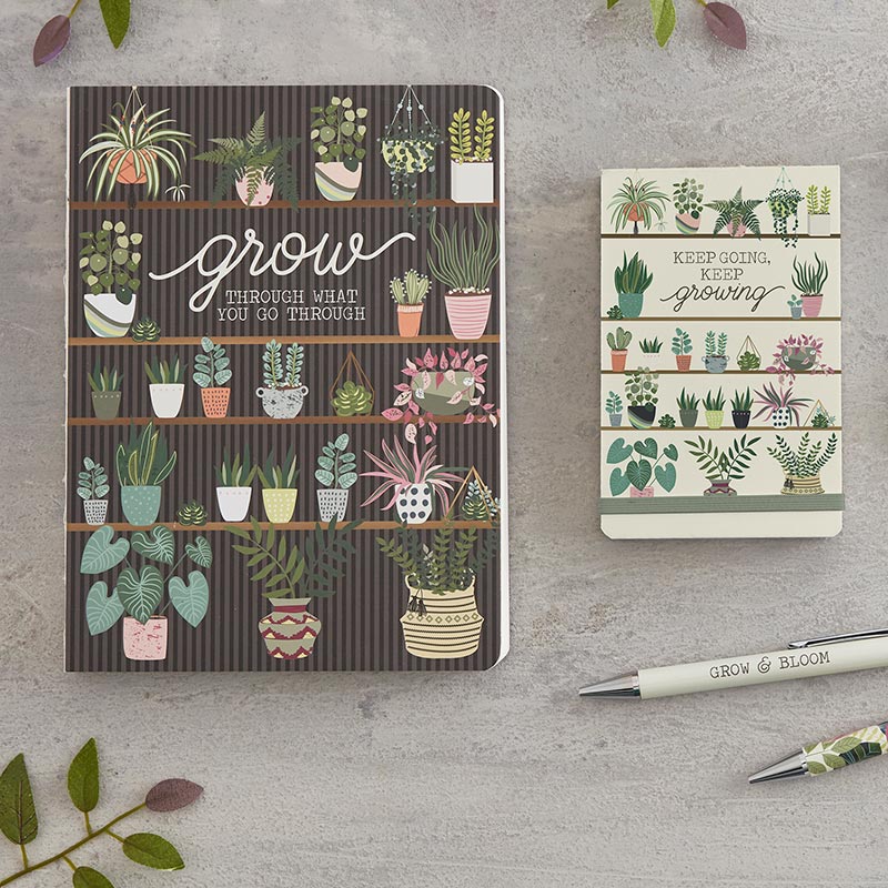 Grow & Bloom Pen Set of 2 featuring a white pen with 'Grow and Bloom' text and a colorful foliage print pen in teal, pink, and green, elegantly boxed.