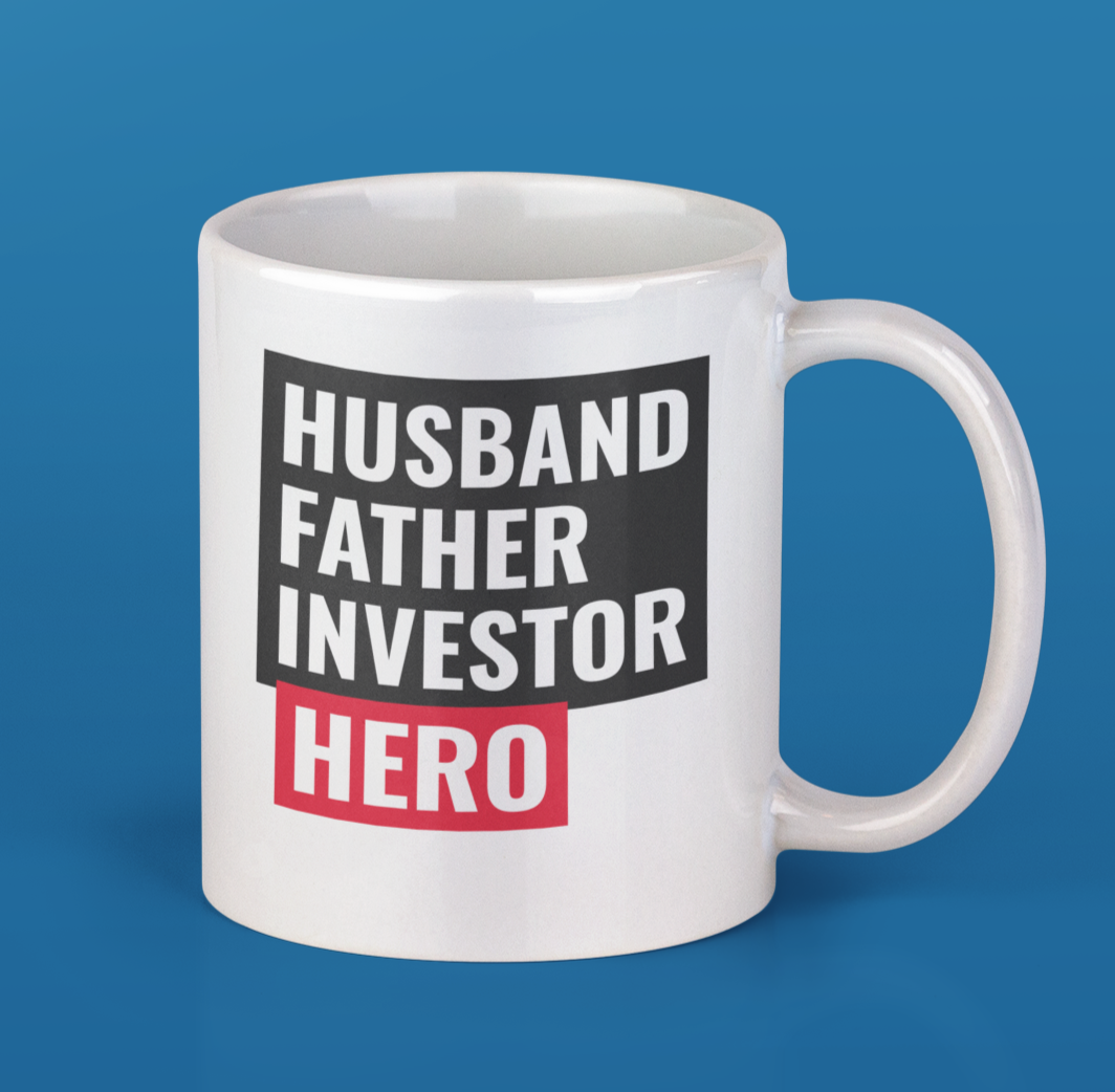 A white ceramic mug featuring the text 'Husband, Father, Investor, Hero' with a classic rounded design and C-handle.