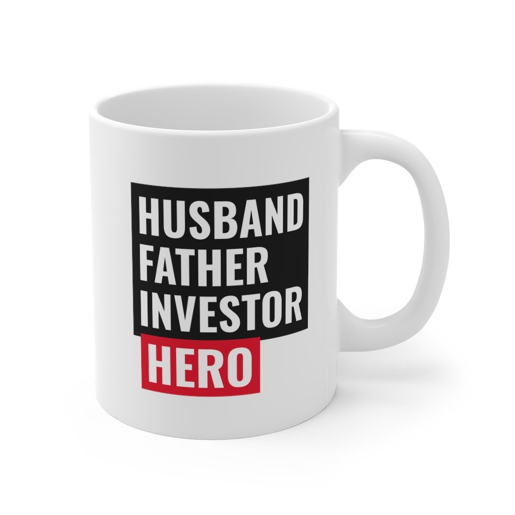 A white ceramic mug featuring the text 'Husband, Father, Investor, Hero' with a classic rounded design and C-handle.