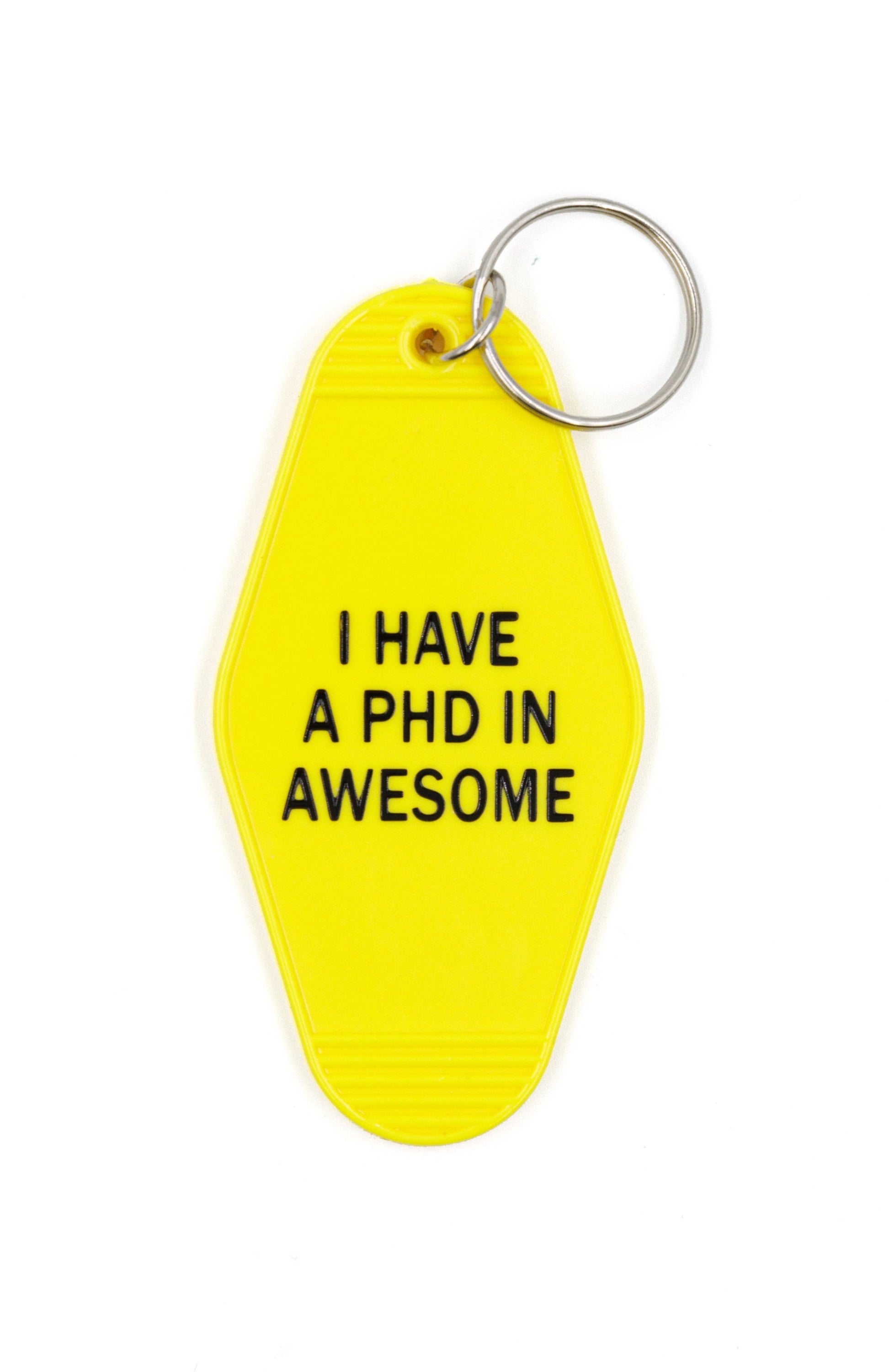 Bright yellow motel-style keychain with black lettering stating 'I HAVE A PHD IN AWESOME', attached to a split ring.