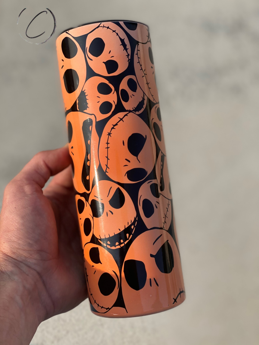 Jack Skellington 20oz UV Orange Skinny Tumbler with color-changing effect in sunlight, featuring a full wrap design and reusable straw.