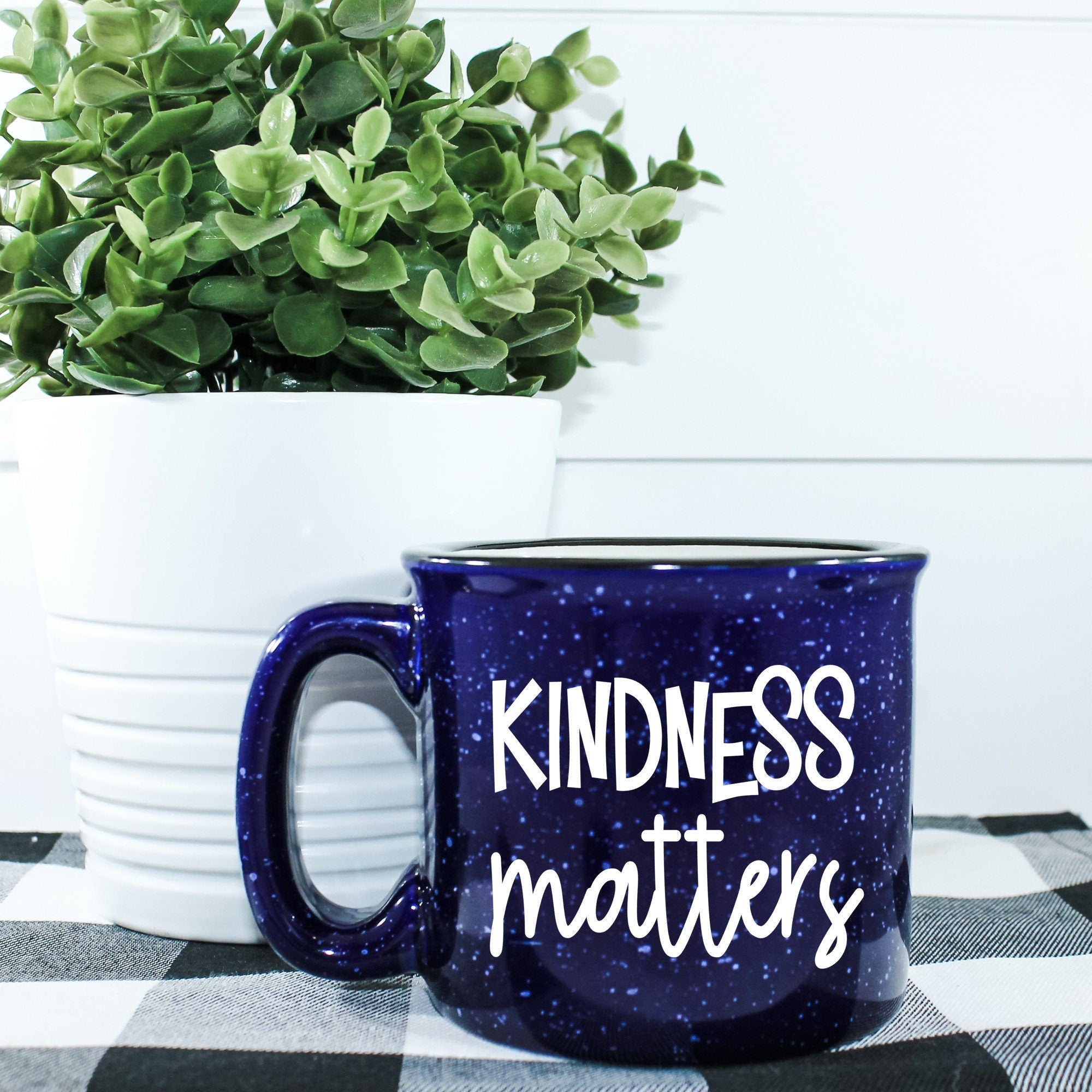 A stylish Kindness Matters Campfire Mug with a unique vinyl design, perfect for enjoying hot beverages.