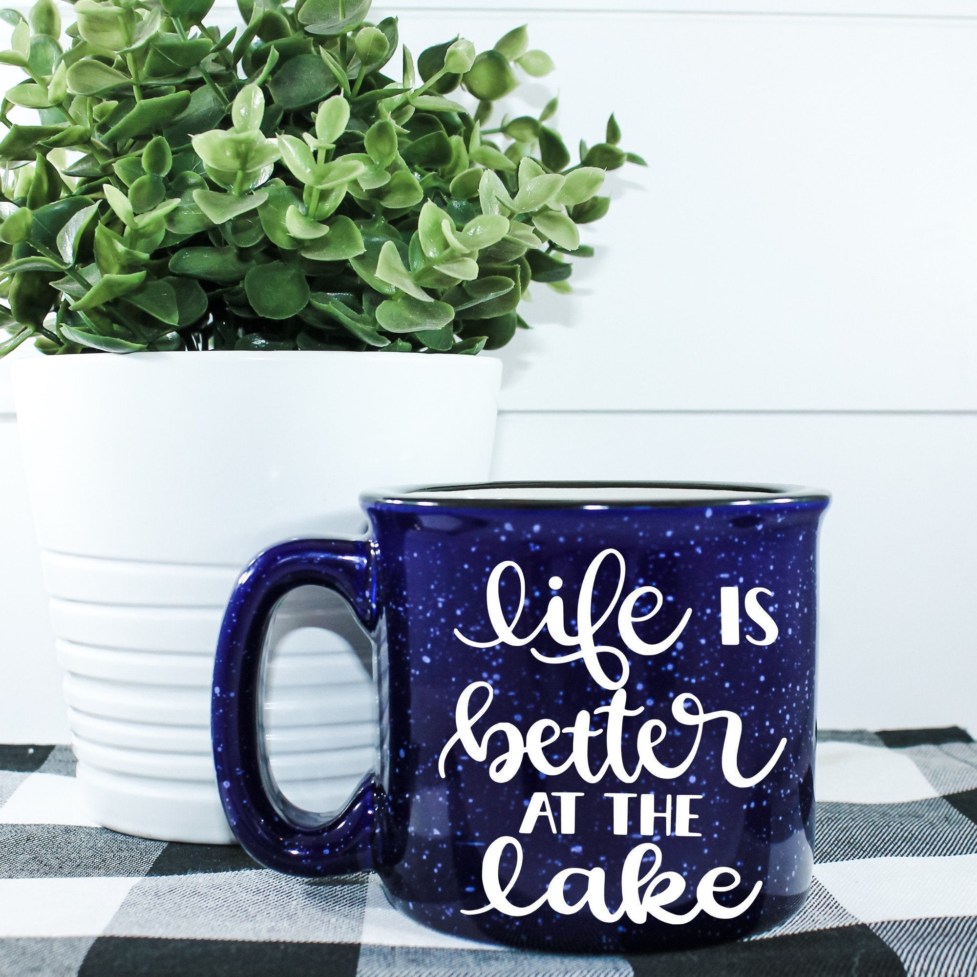 Ceramic campfire mug with 'Life Is Better At The Lake' design, perfect for enjoying beverages by the water.