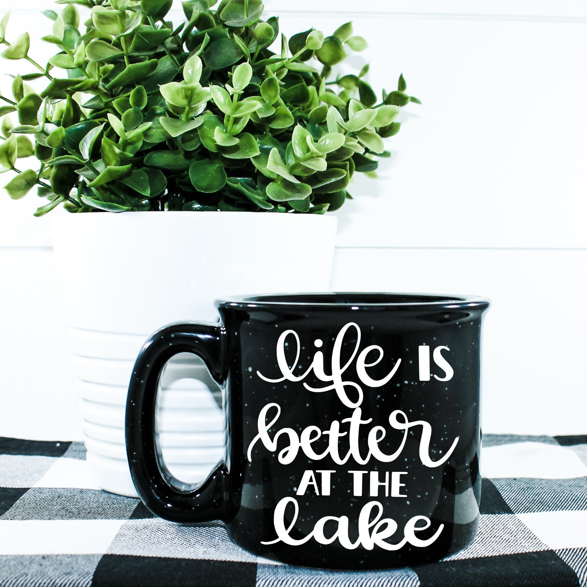 Ceramic campfire mug with 'Life Is Better At The Lake' design, perfect for enjoying beverages by the water.